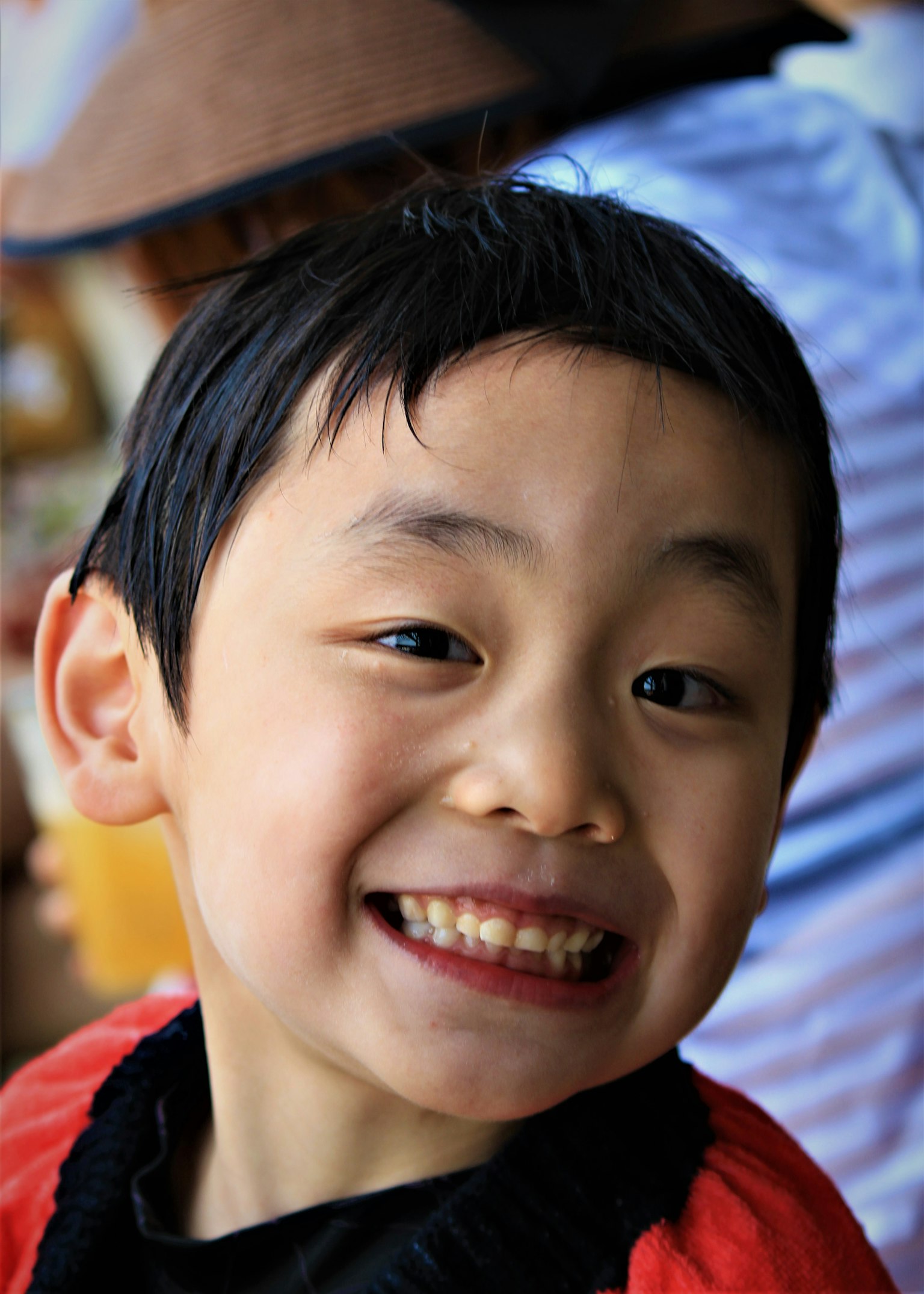 เด็กชายยิ้มใส่เสื้อแดง