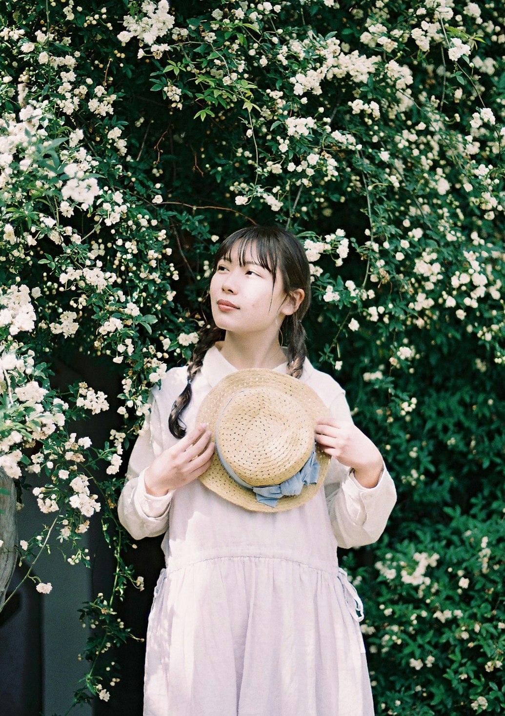 niña entre flores blancas con sombrero de paja