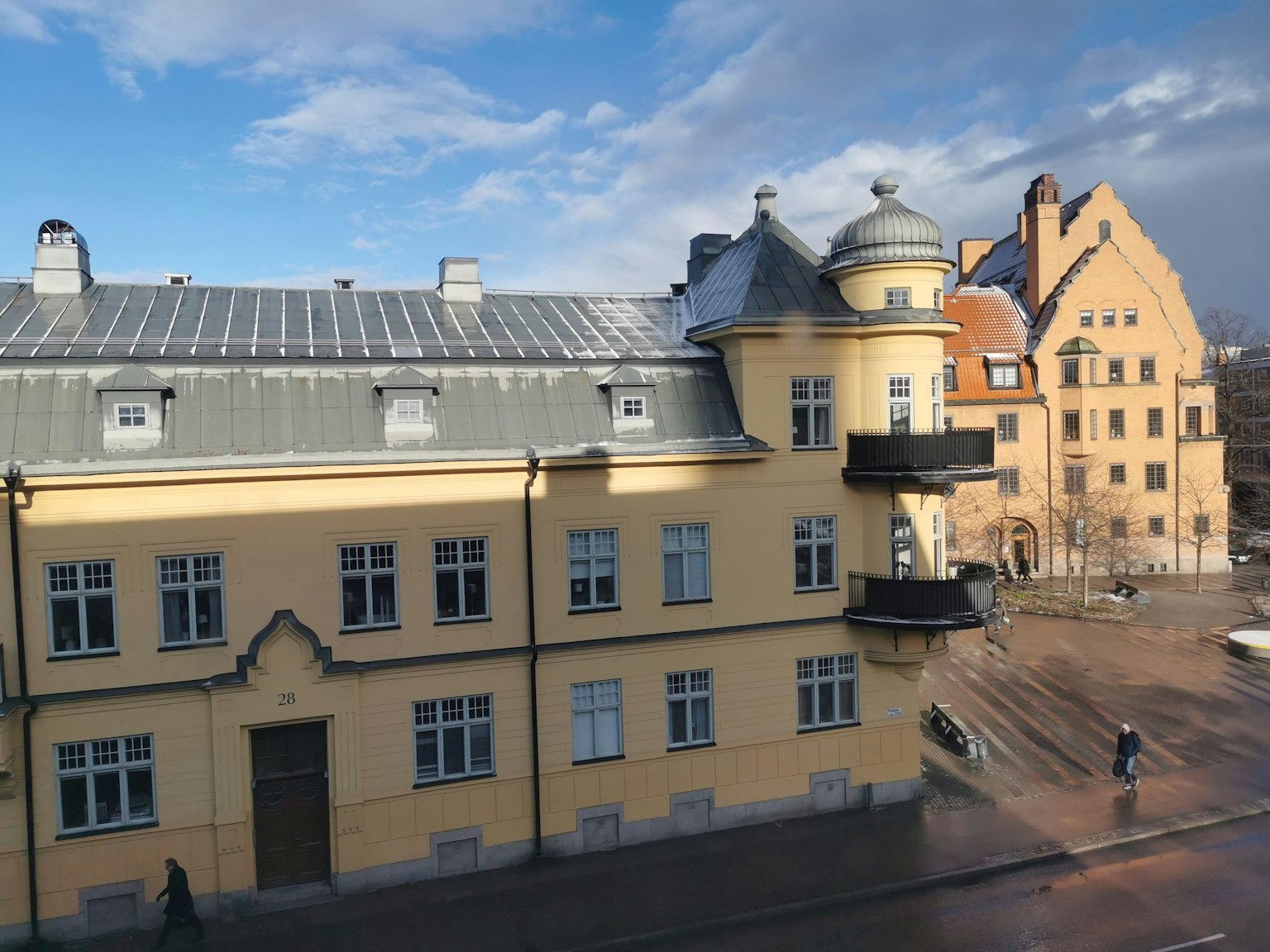 Historic building with bright yellow facade and modern roof design