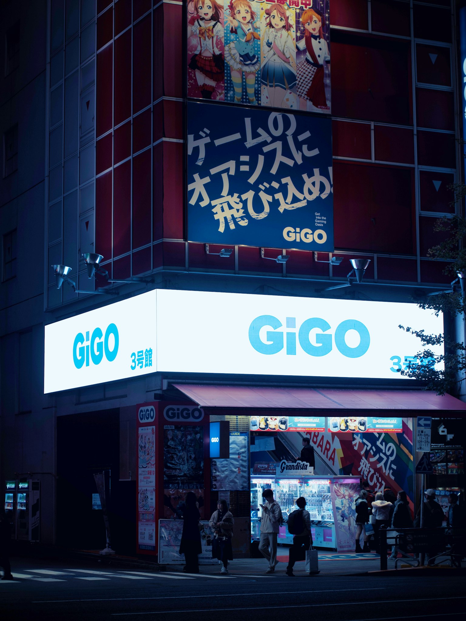 ゲームセンターの外観に明るい看板と人々が集まる様子