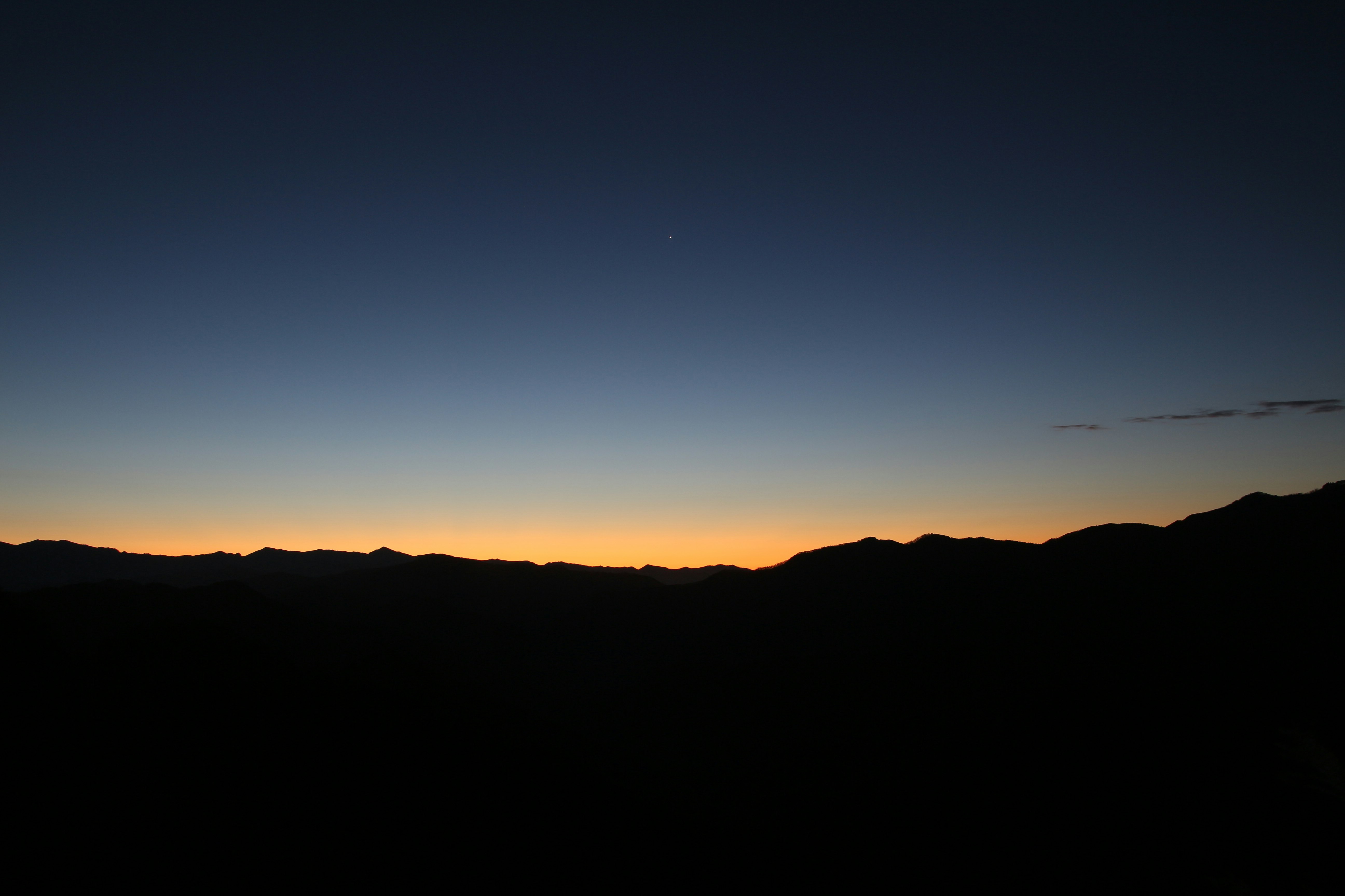 silhuetas de montañas frente a un cielo de atardecer