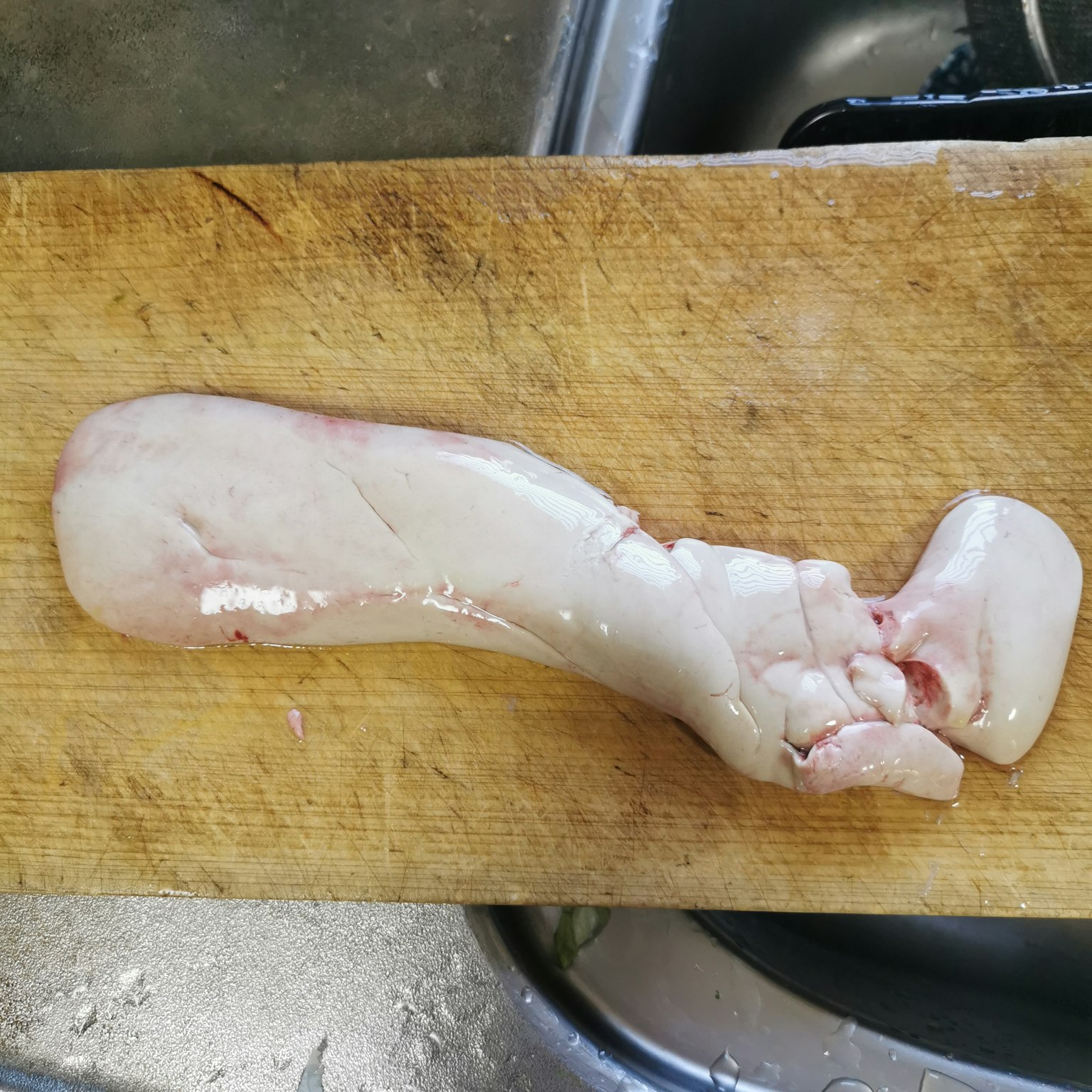 A piece of meat lying on a wooden cutting board
