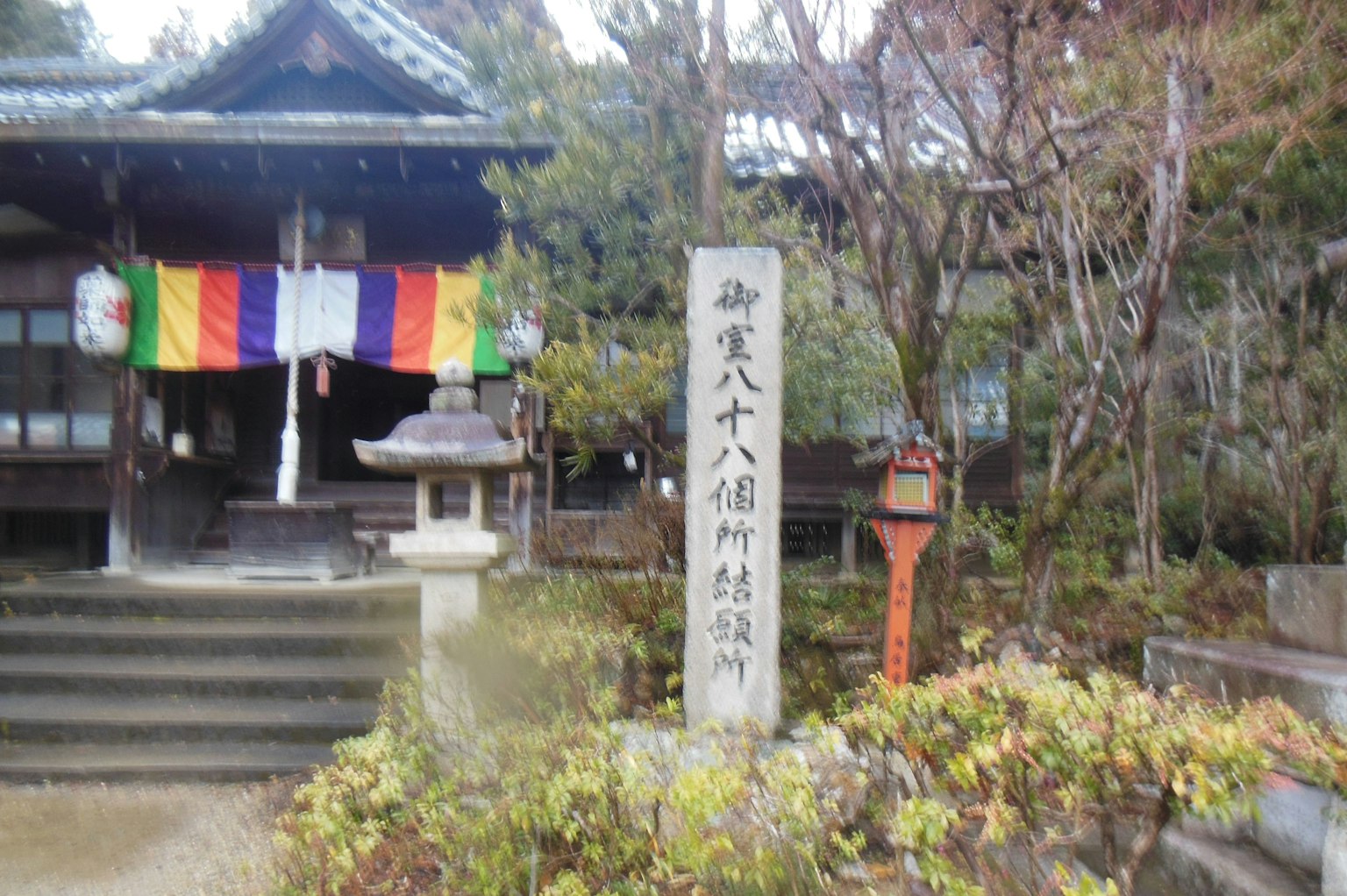 사원 입구에 있는 돌 기념물과 다채로운 깃발