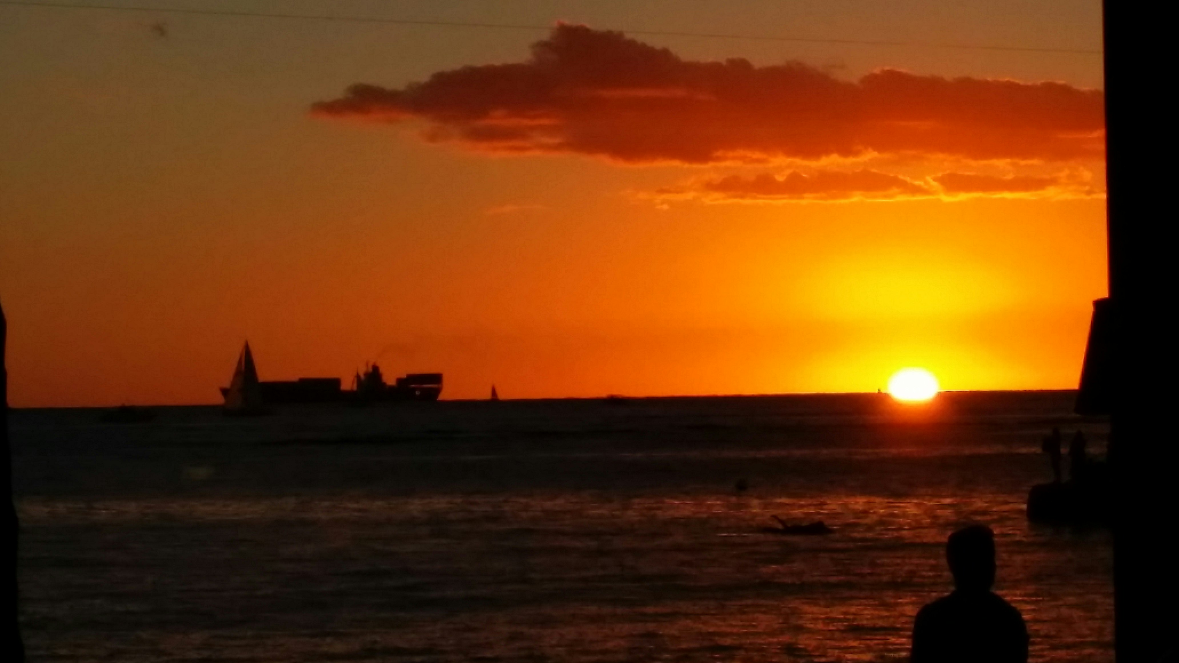 夕日に照らされる海辺の水平線と雲