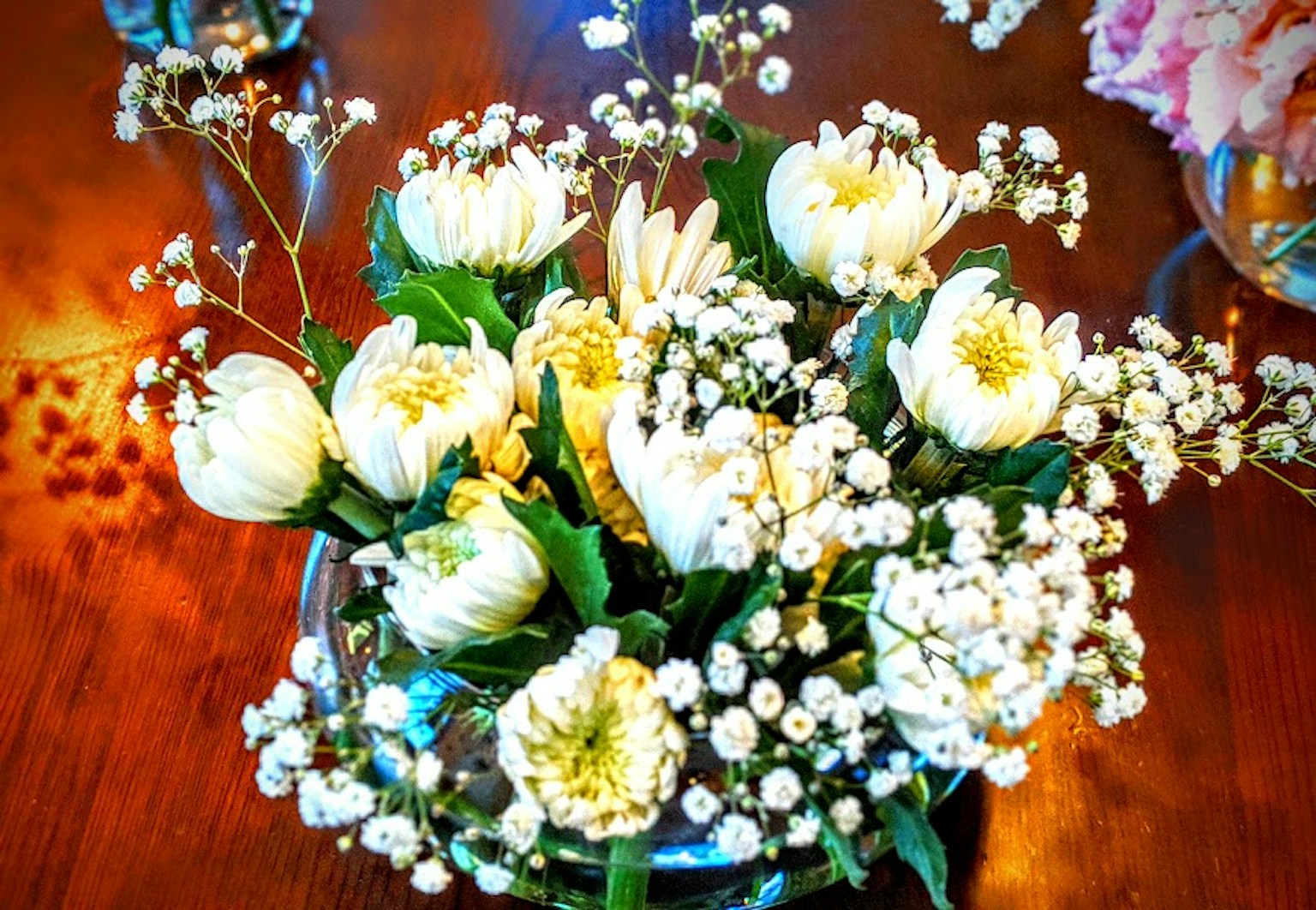 Un mazzo di fiori bianchi e di fiorellini di gipsophila su un tavolo di legno