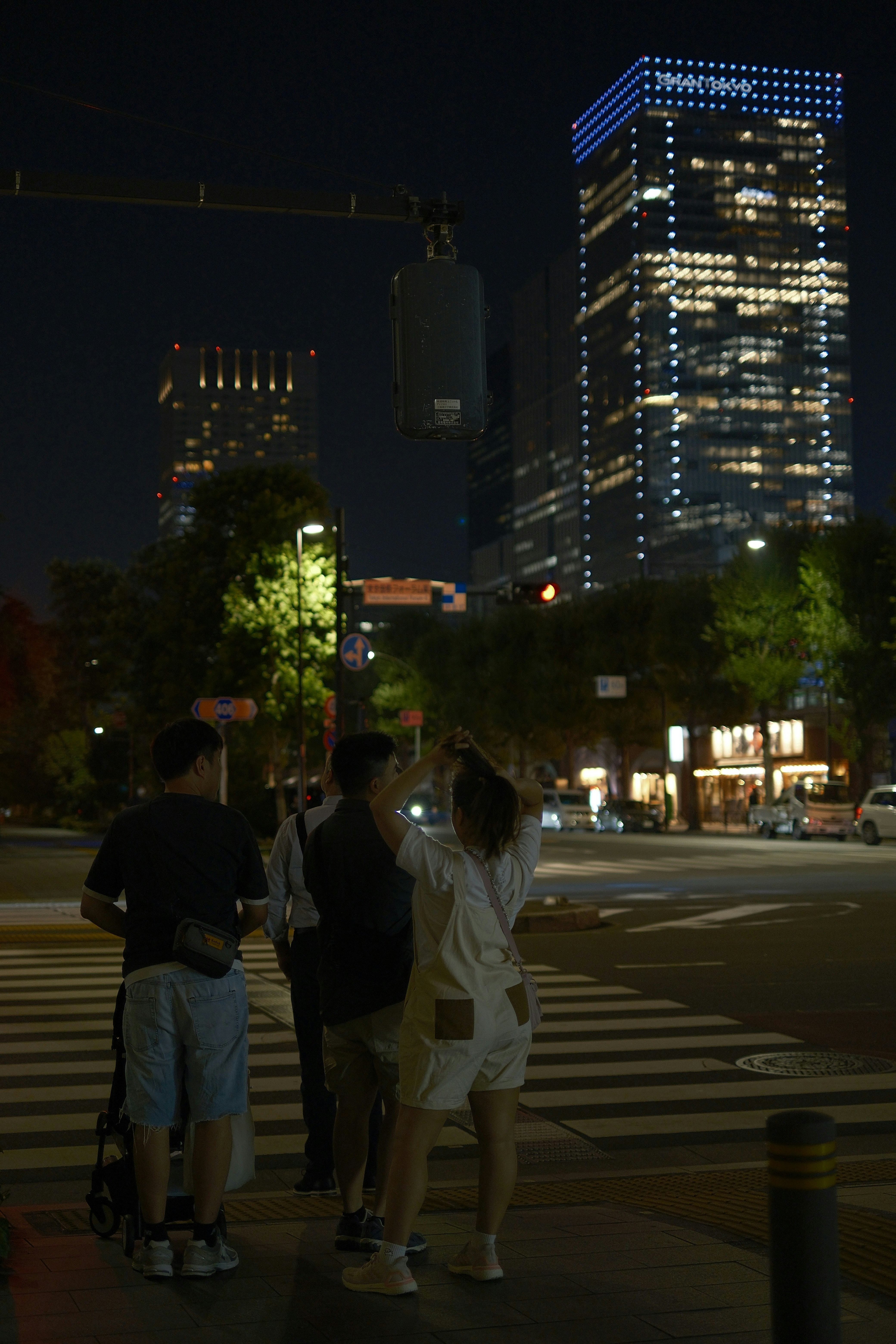 夜の大通りで見上げる東京の高層ビル群
