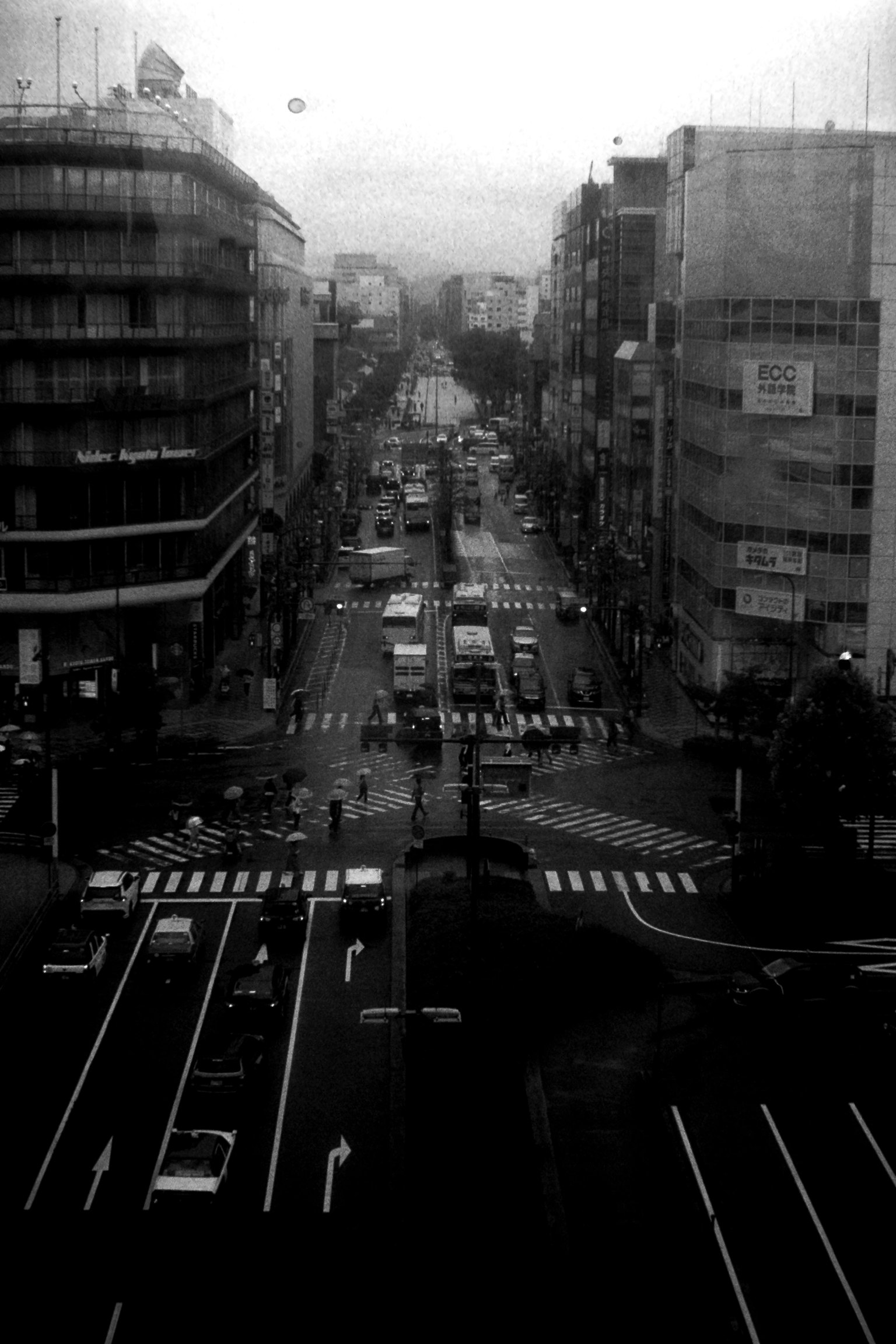Vista en blanco y negro de una intersección urbana mostrando calles y pasos de peatones