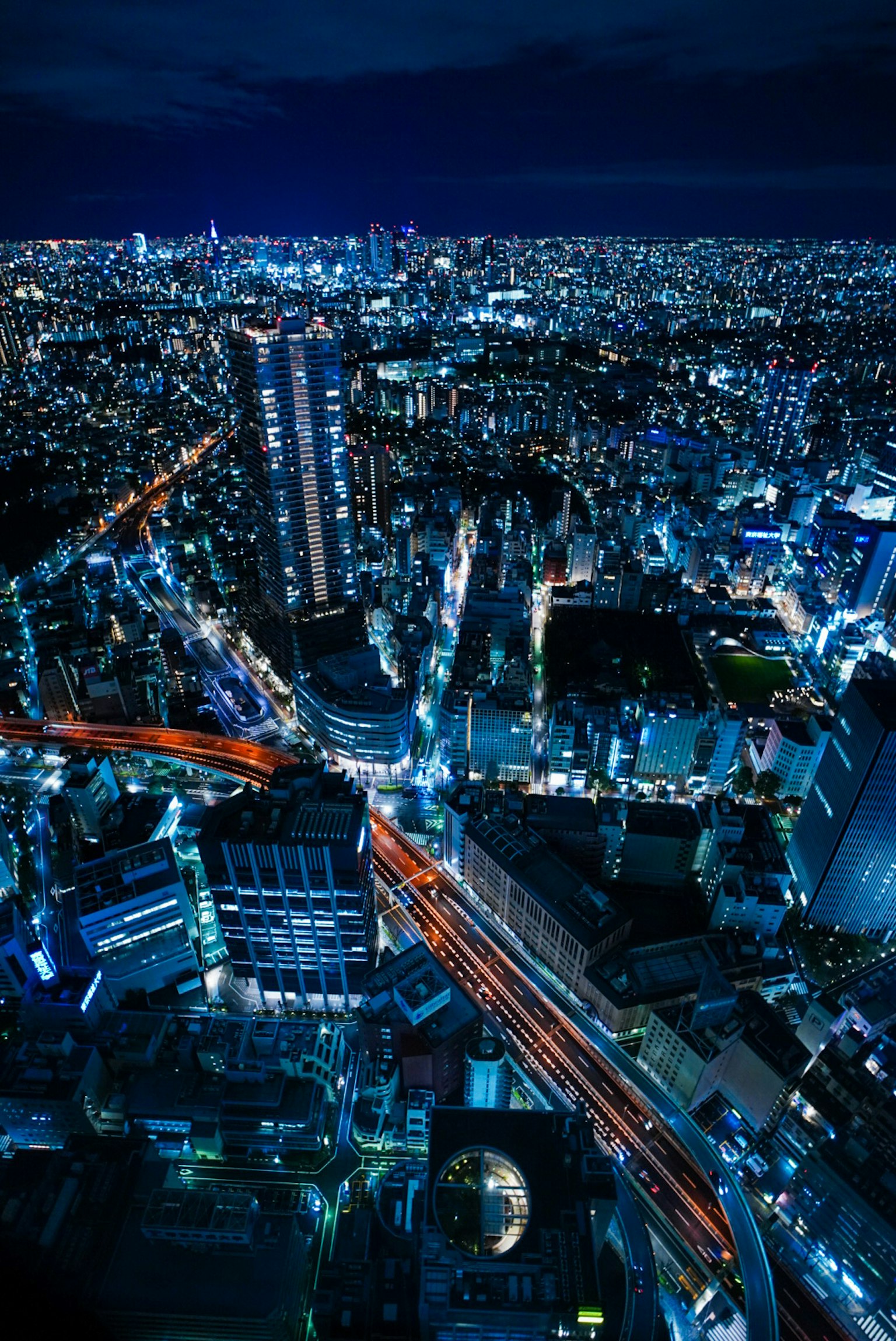 Vista aérea del horizonte de Tokio con luces nocturnas vibrantes y calles concurridas