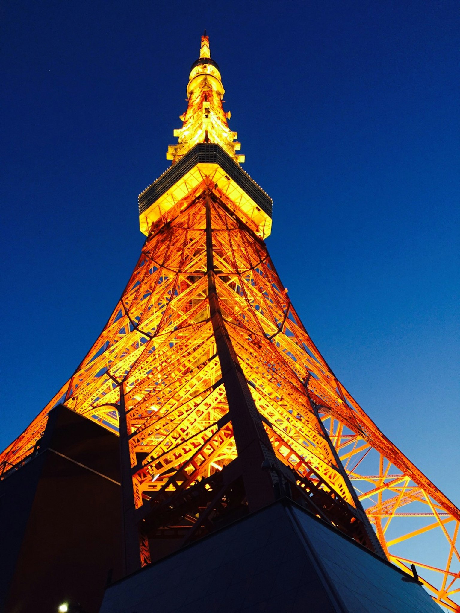 Torre di Tokyo illuminata di notte contro un cielo blu