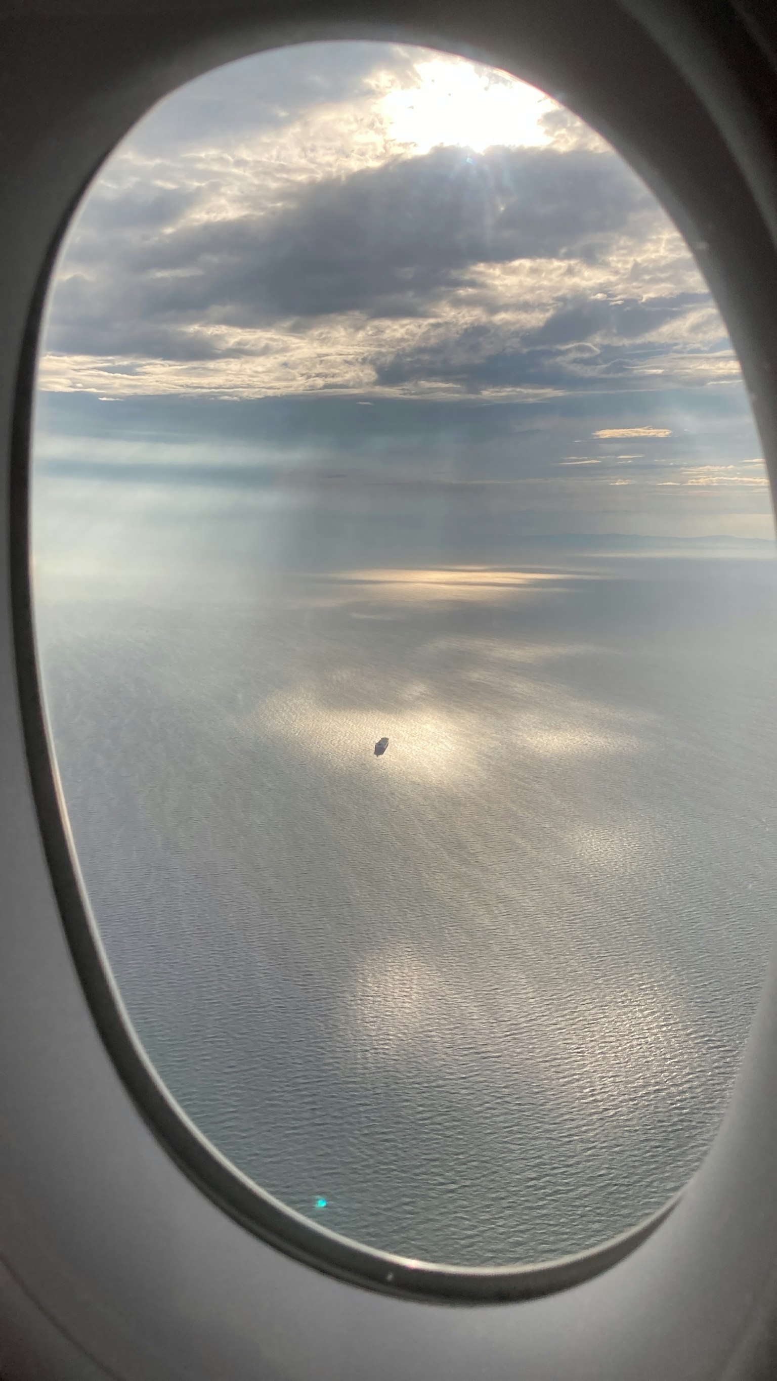 Vista del océano con nubes desde una ventana de avión