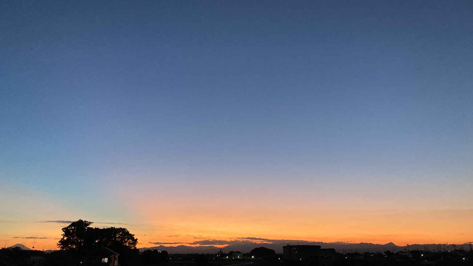Schöner Sonnenuntergangshimmel mit Silhouette von Bergen