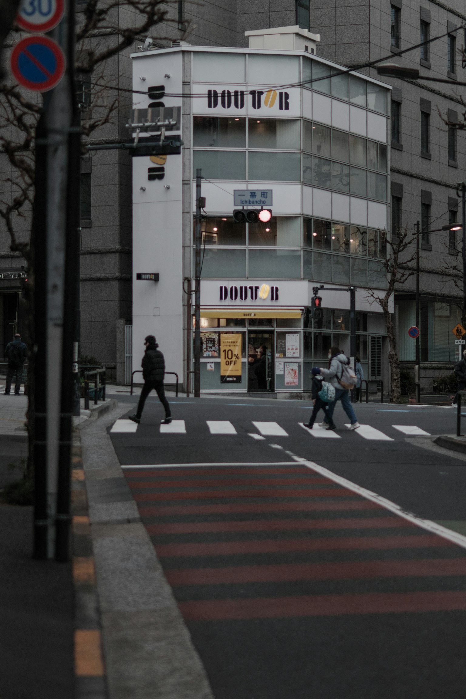 Foto di un edificio bianco con pedoni che attraversano la strada
