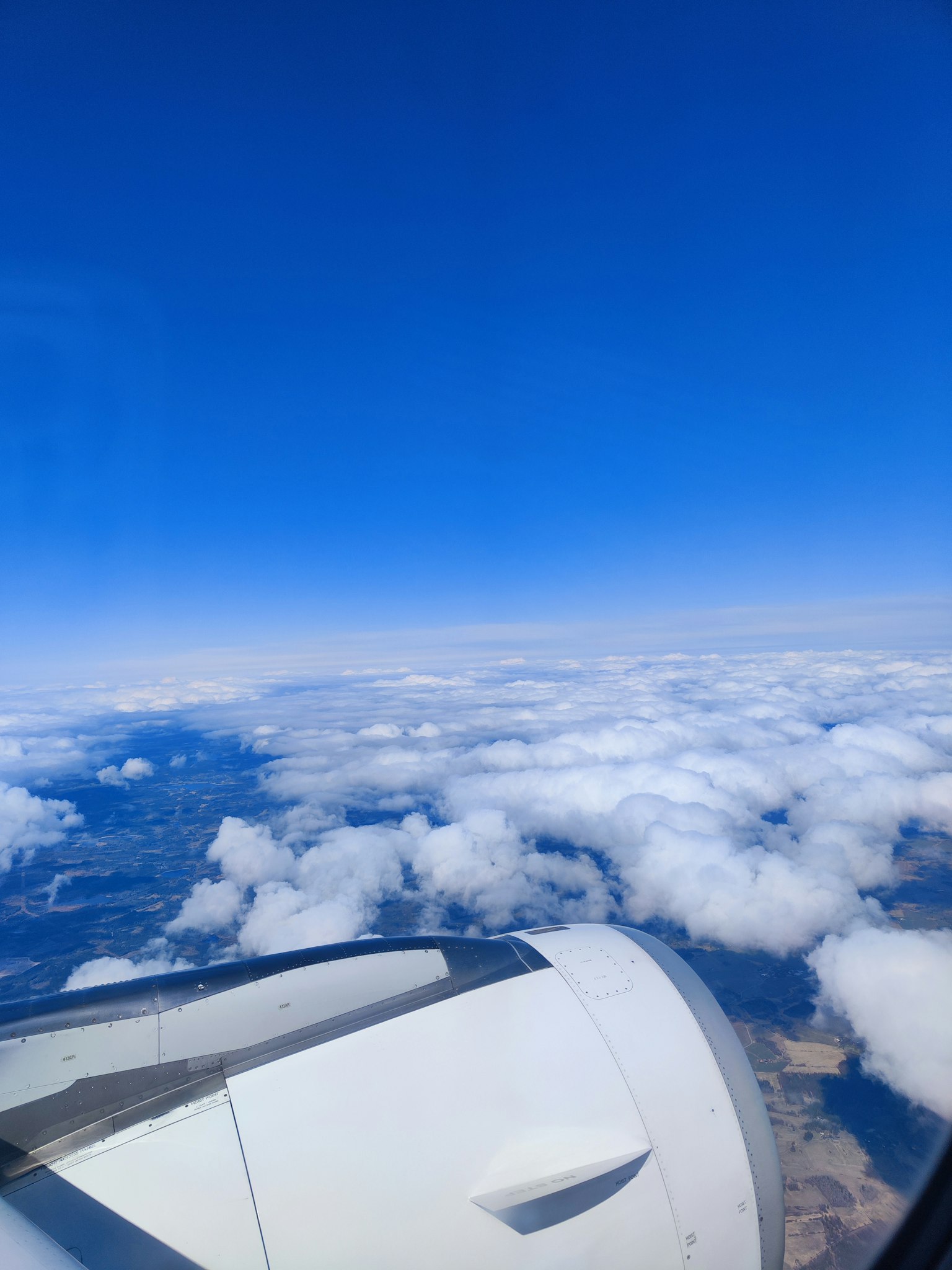 Flugzeugtriebwerk mit Wolken und blauem Himmel