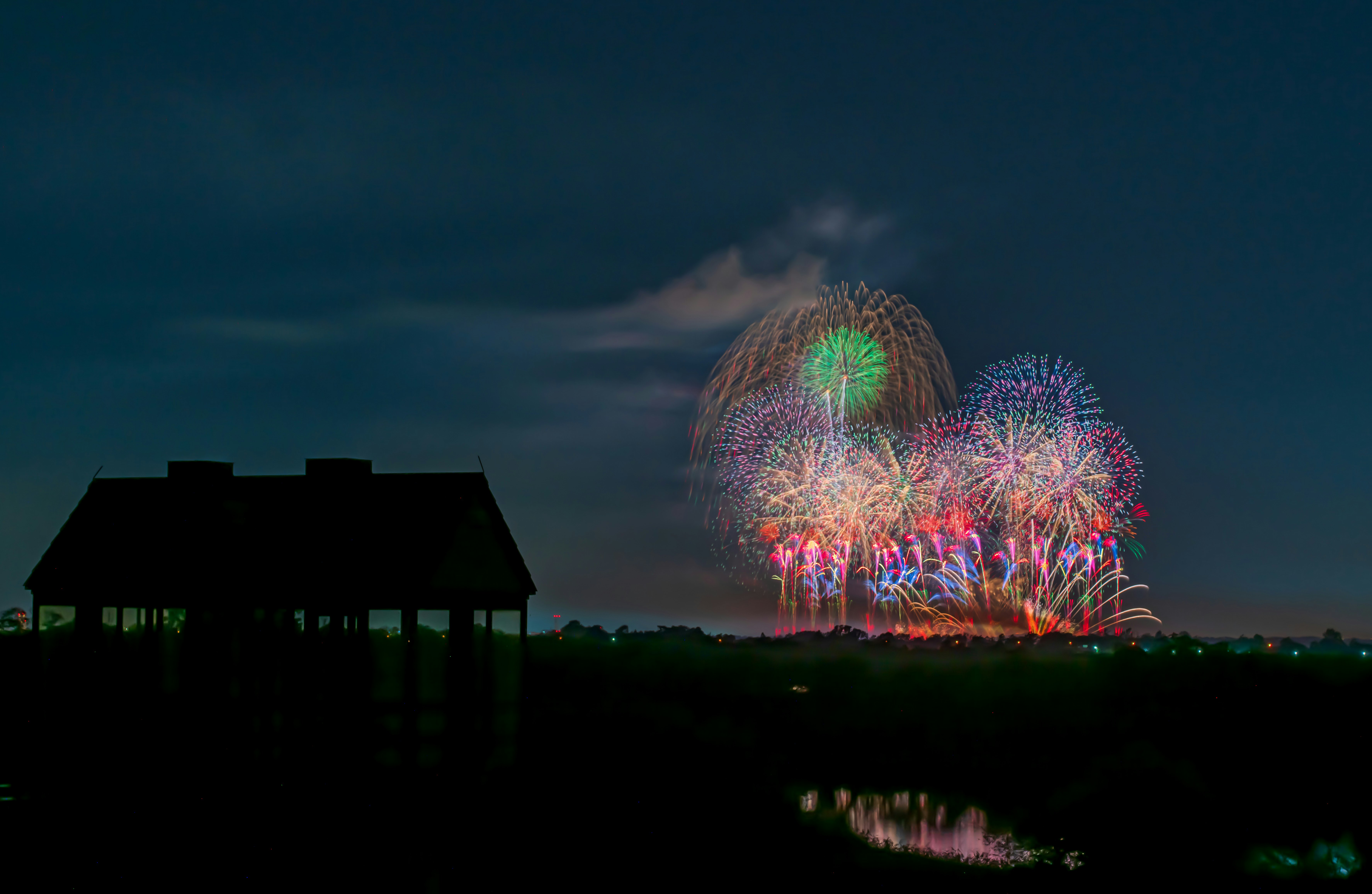 夜空に咲く花火のような光の大輪と水面の反射