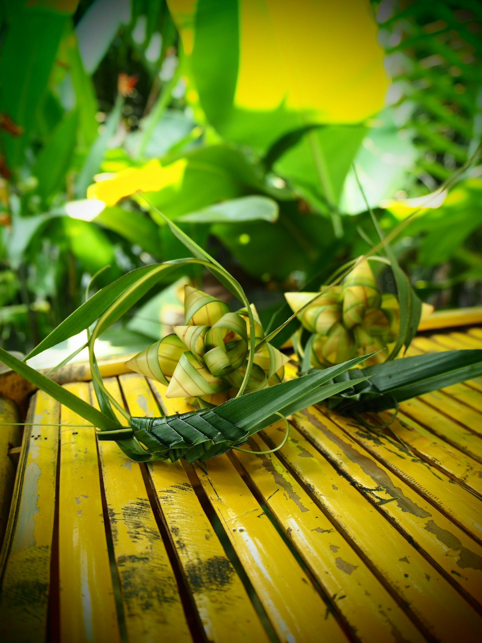 Frutos similares a piñas colocados sobre una superficie amarilla rayada rodeados de hojas verdes