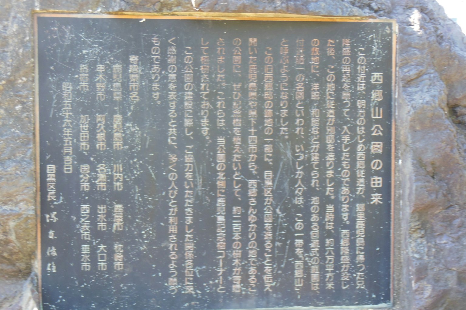 Una placa negra con texto grabado rodeada de piedra