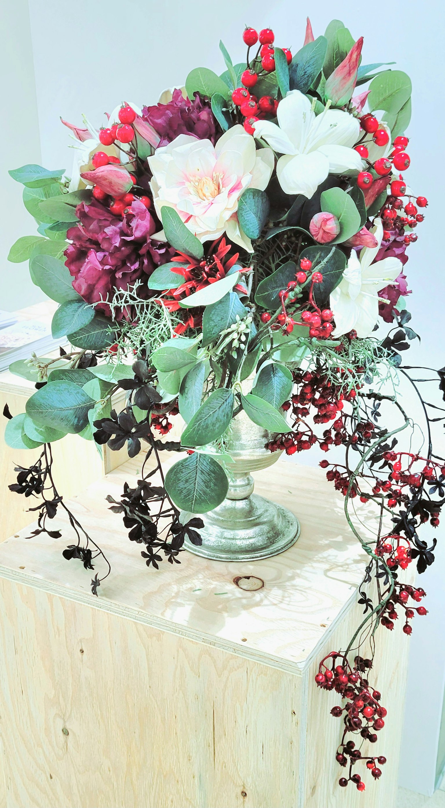 Ein wunderschönes Arrangement aus Blumen und Grün in einer Glasvase