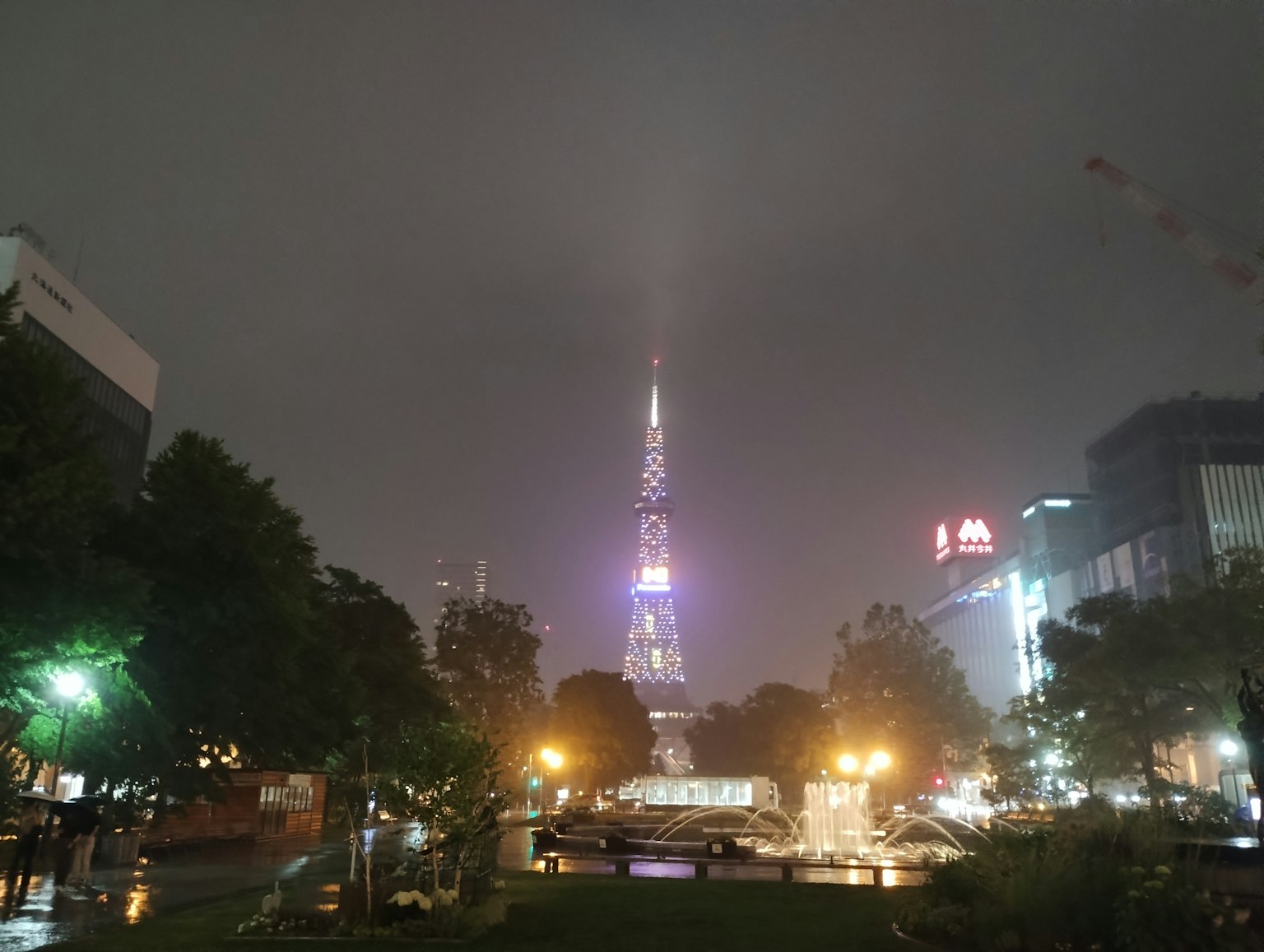 Paysage urbain nocturne avec une tour enveloppée de brouillard et des lumières illuminées