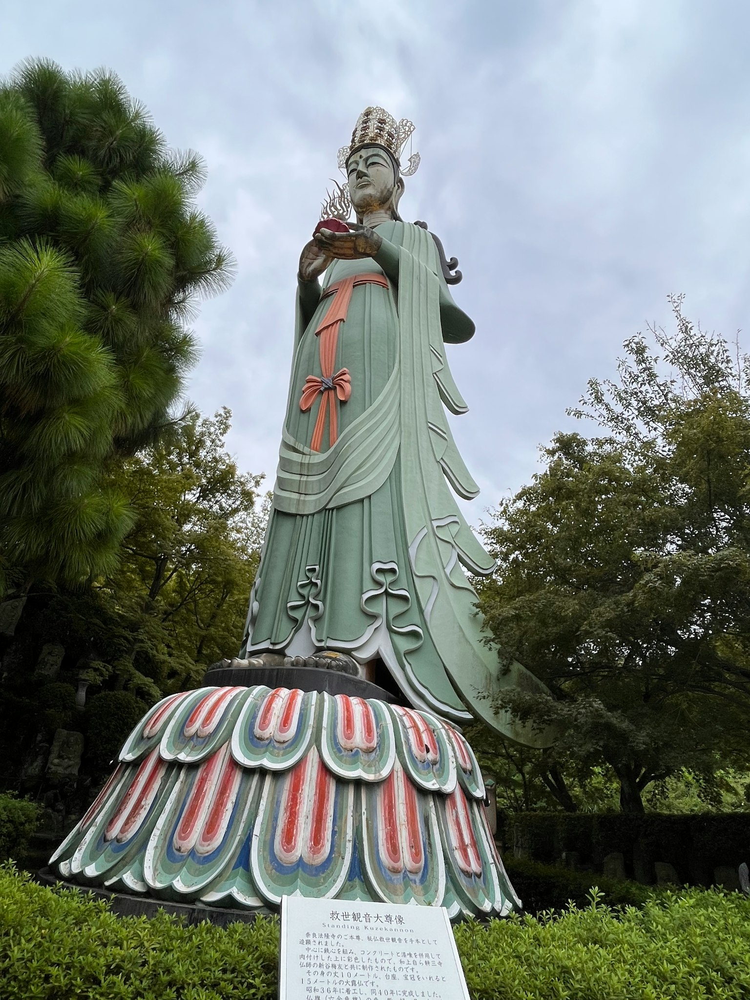 高大的观音像被绿色树木环绕