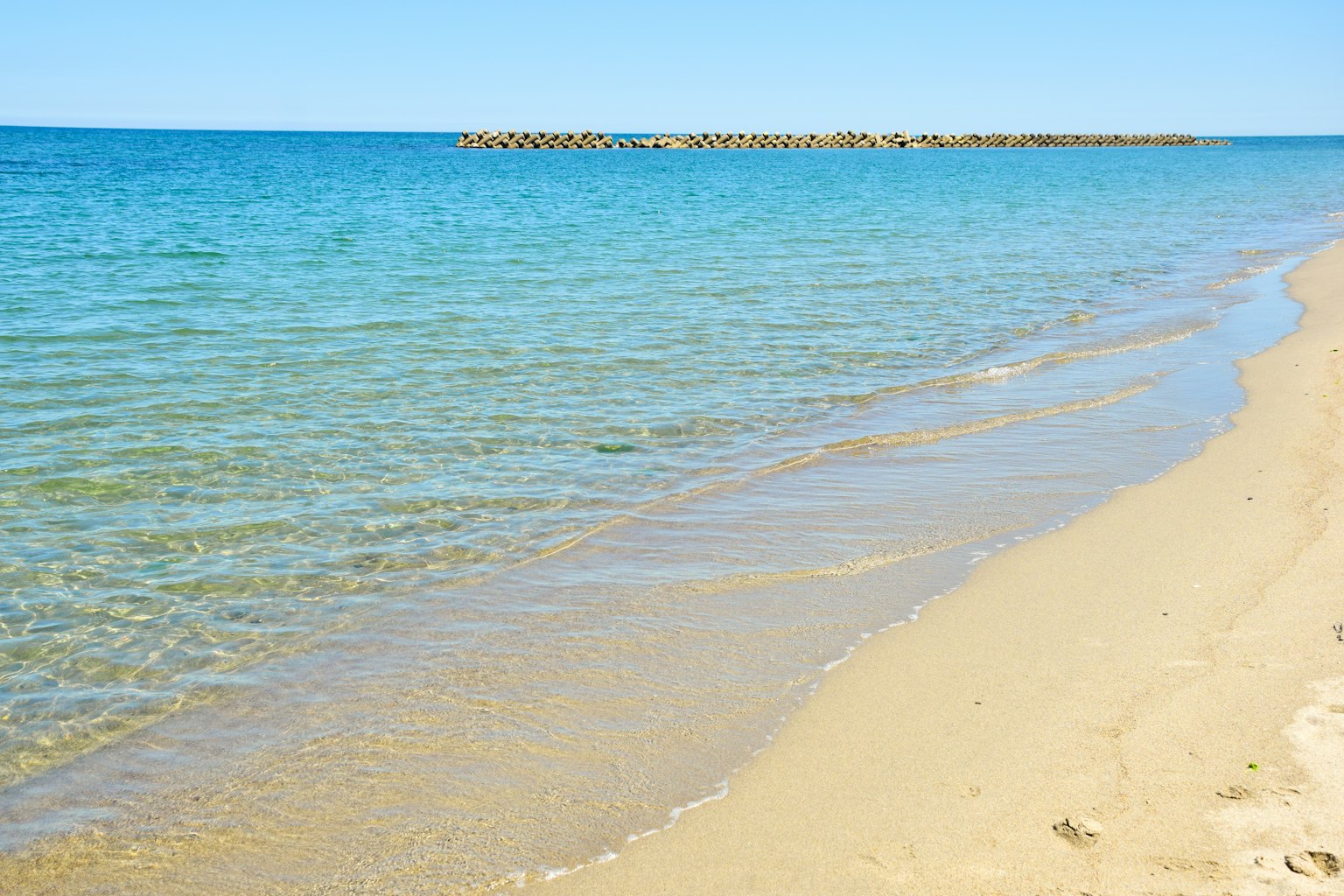 ทิวทัศน์ของชายหาดที่มีน้ำสีฟ้าและชายหาดทราย