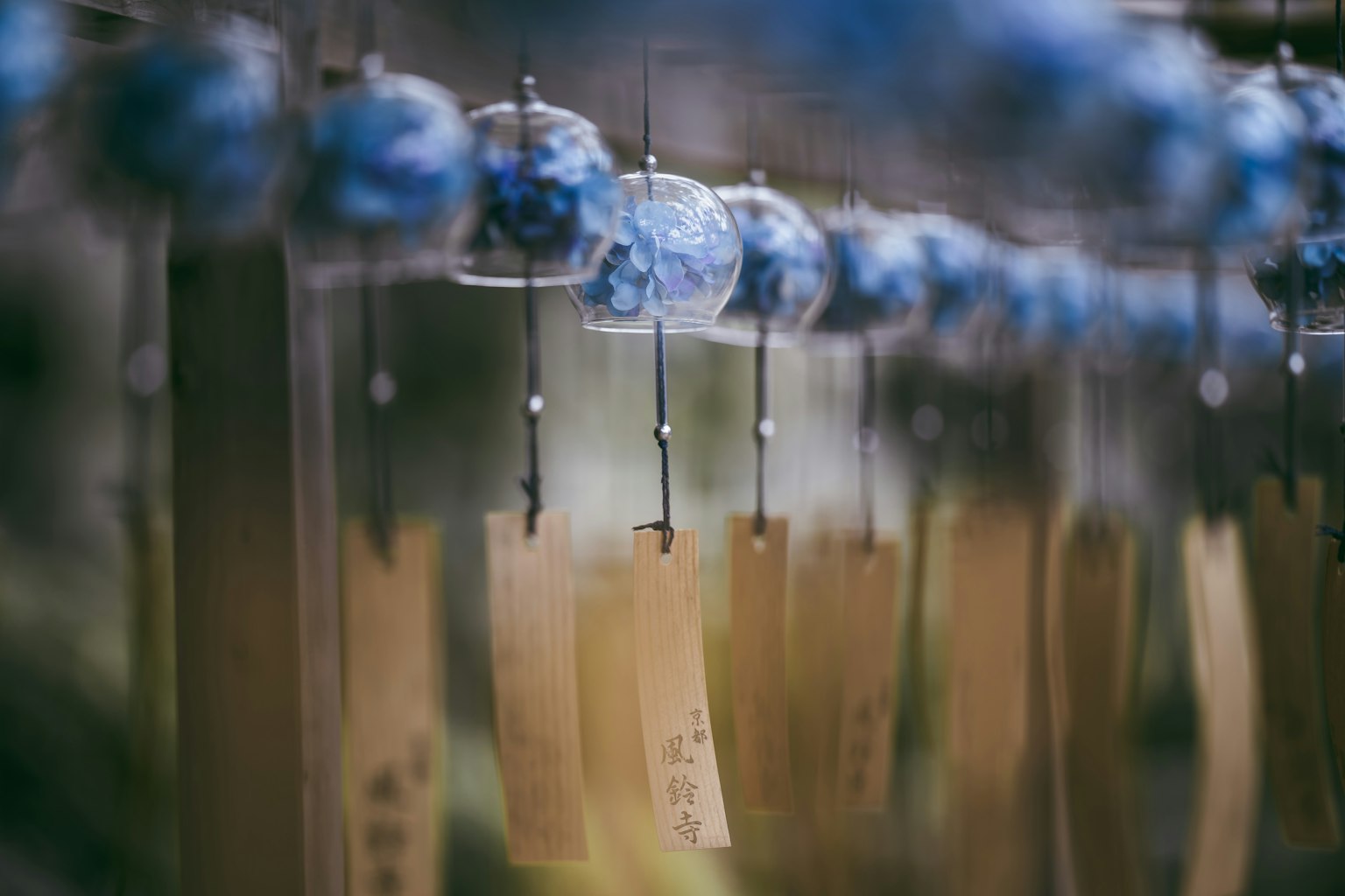 Blaue Windspiele und hängende Papierstreifen mit Schrift