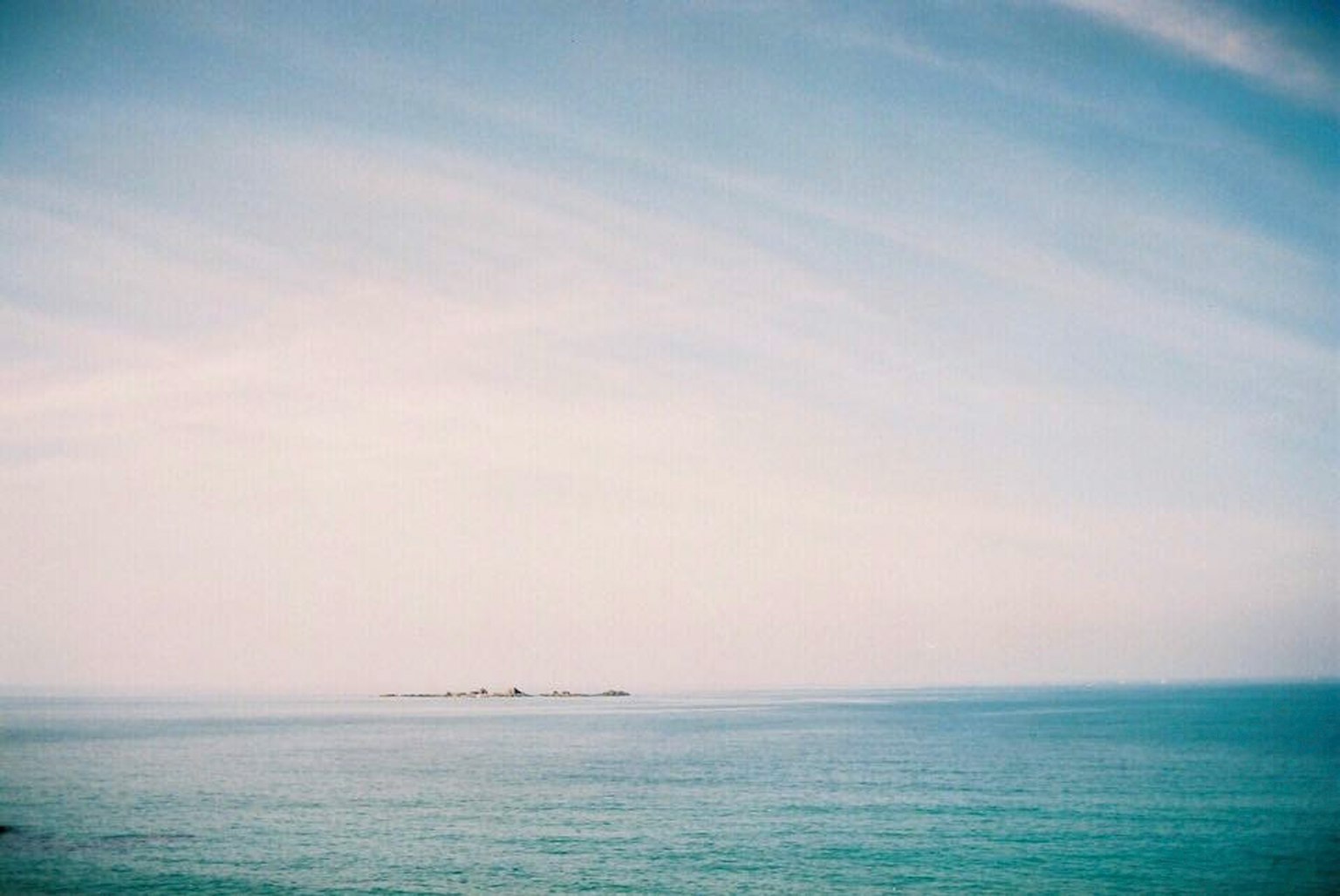 Vista serena del mare e del cielo azzurro con un'isola in lontananza