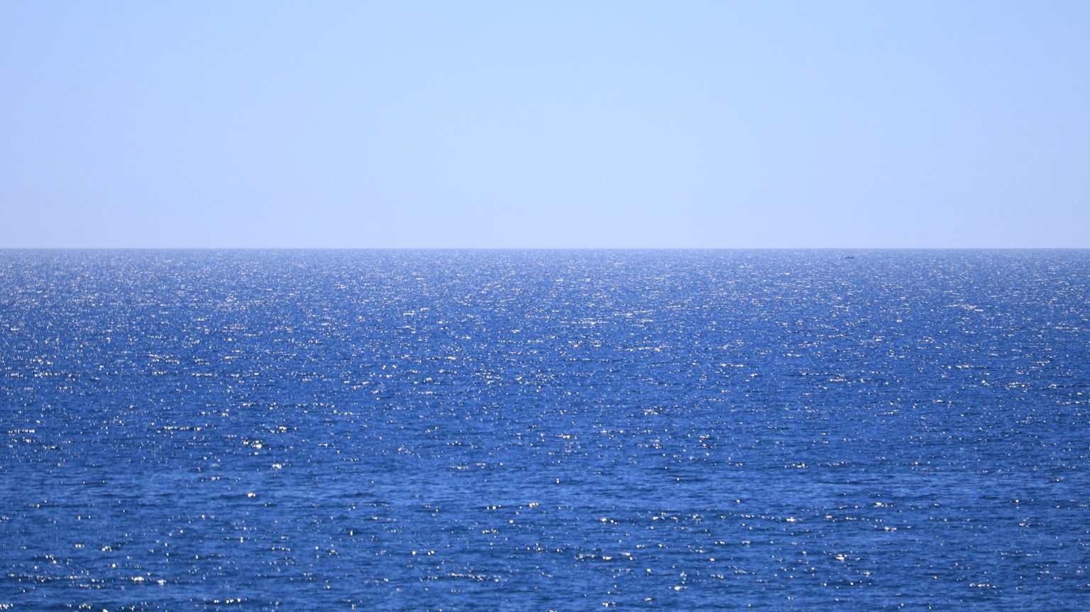 Vasto oceano blu che incontra un cielo sereno