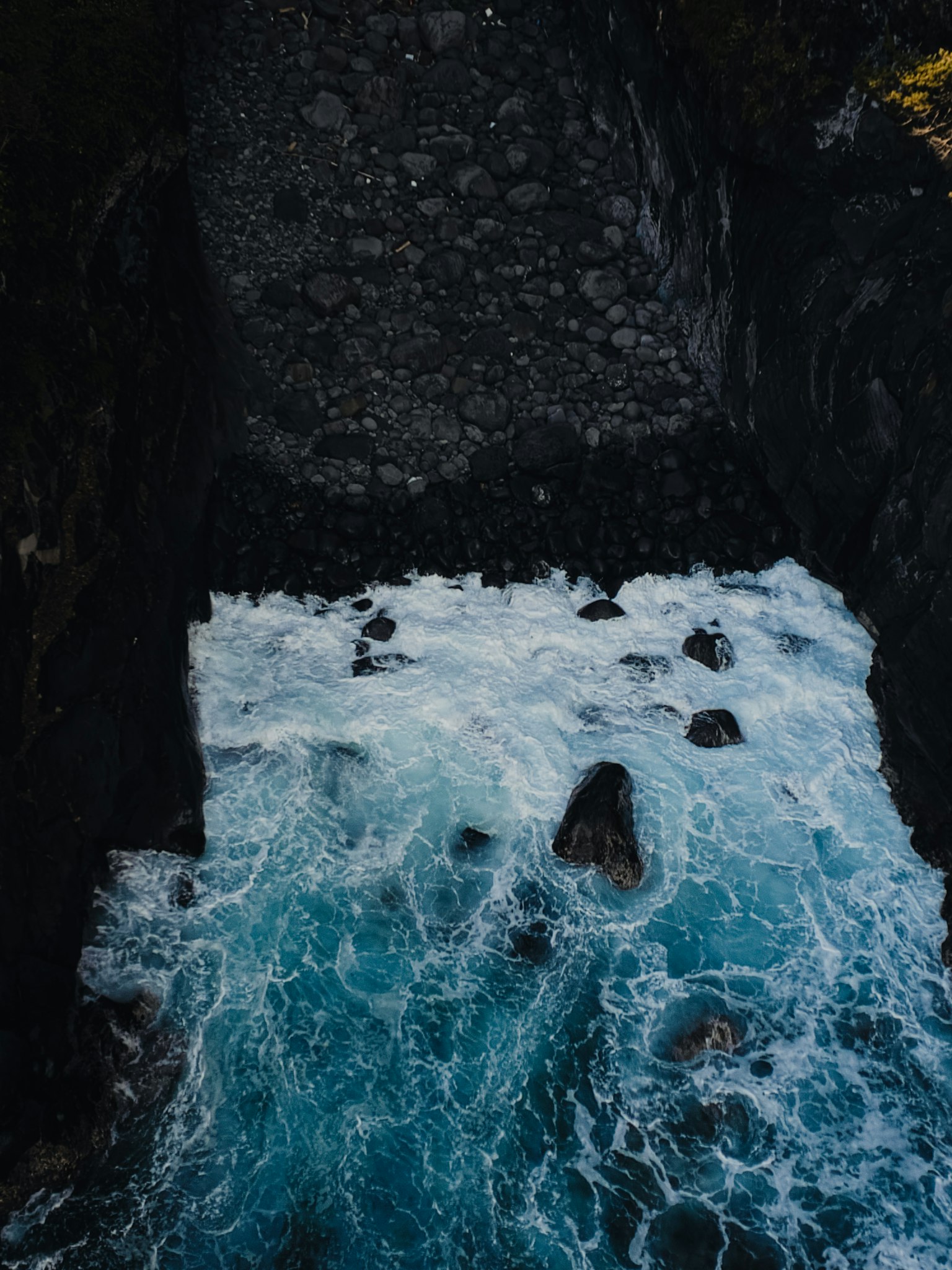 Onde che si infrangono contro le rocce in un oceano blu profondo circondato da scogliere