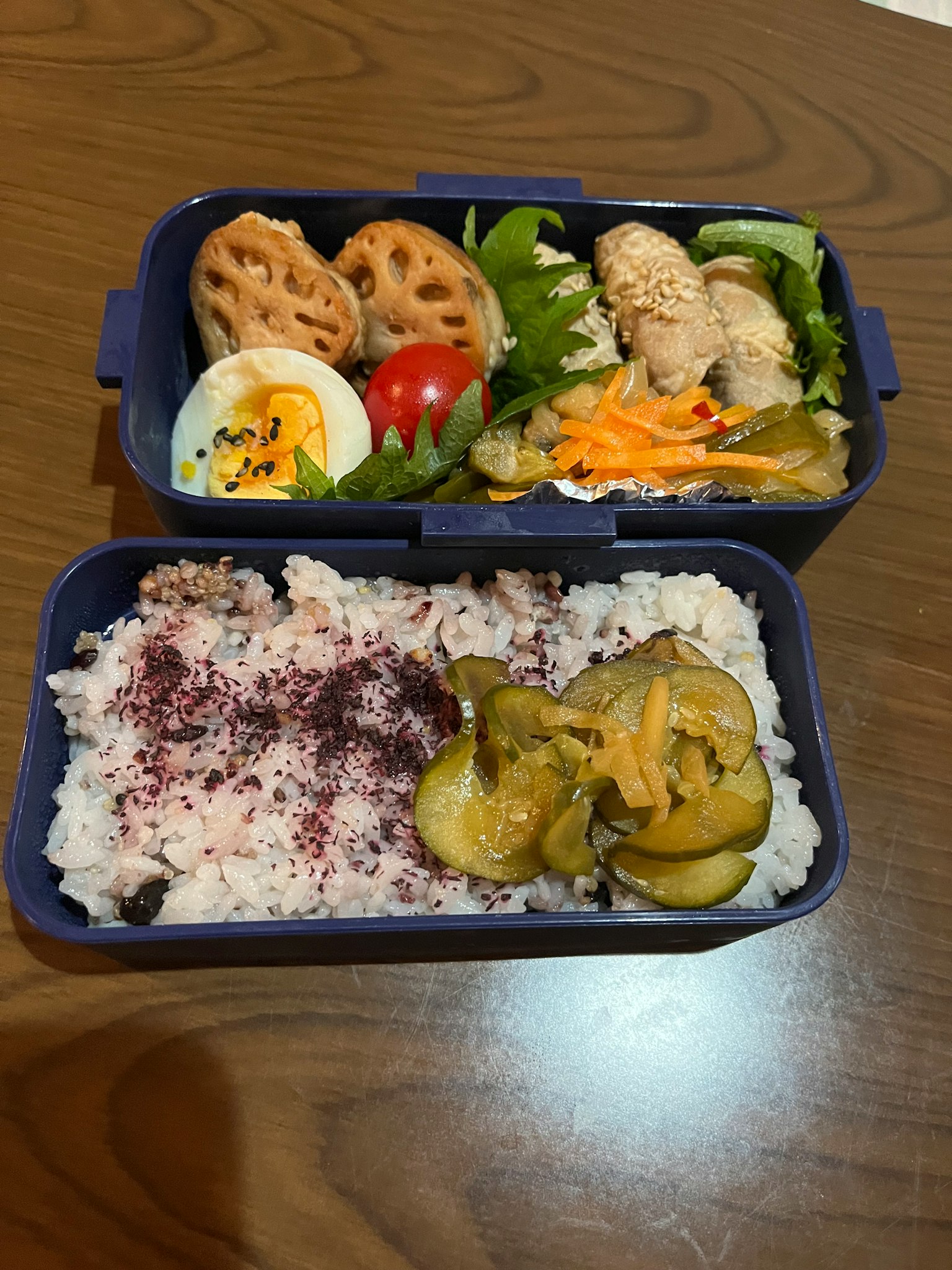 Zweistöckige Bentobox gefüllt mit bunten Gerichten und Reis