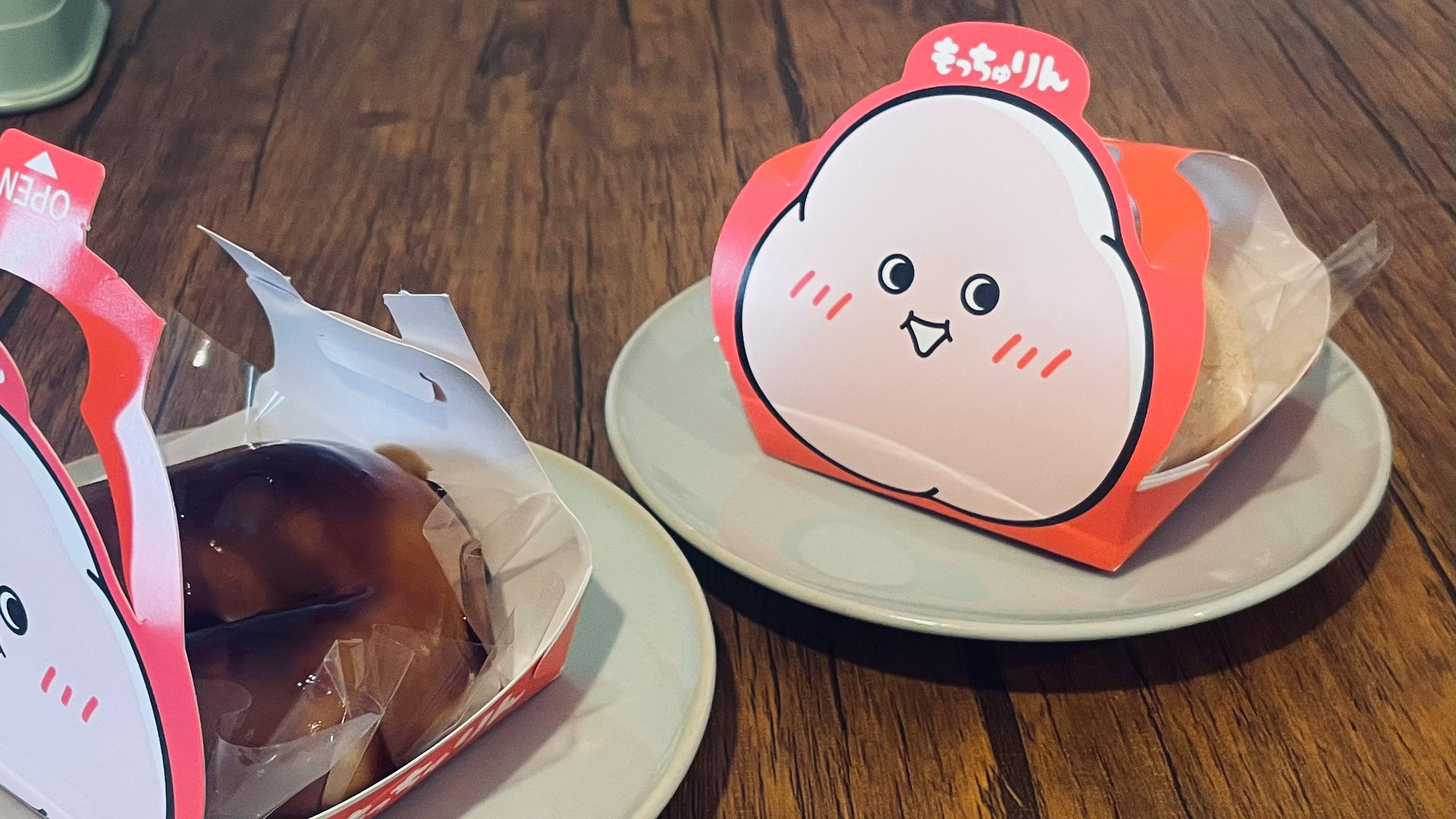木目のテーブルに並ぶキャラクター風の焼き菓子と包装