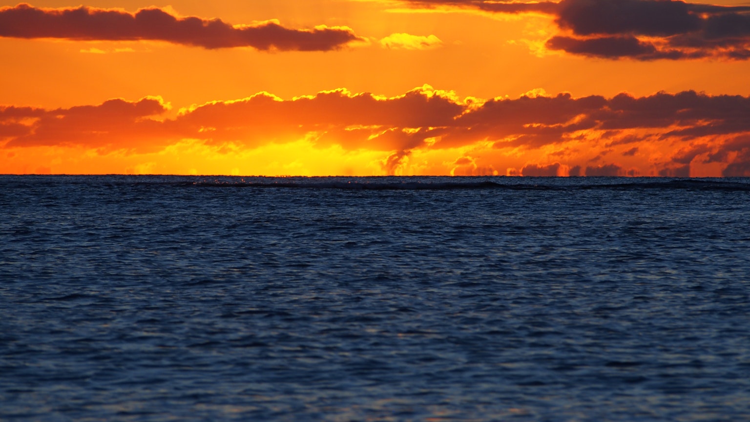Coucher de soleil orange sur l'horizon océanique avec une surface marine bleue