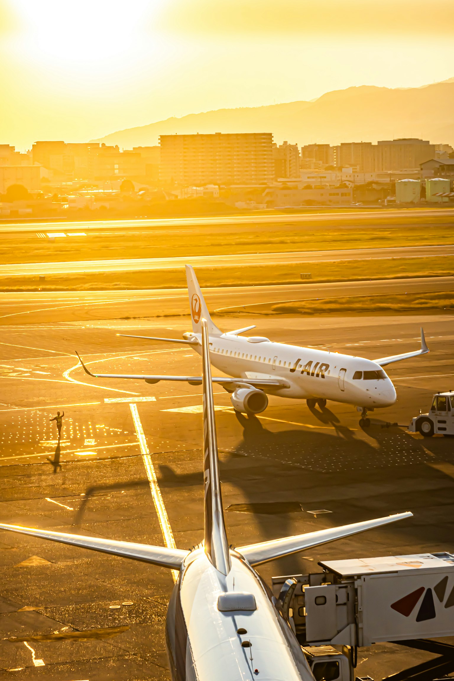 Airplanes taxiing at sunset in an airport