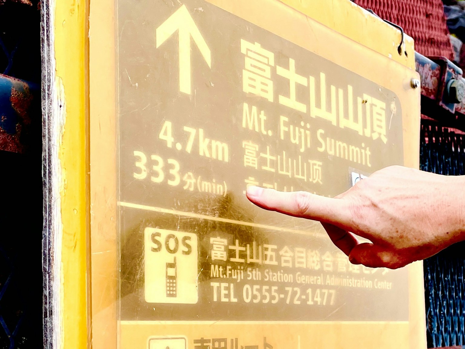 Biển báo màu vàng chỉ khoảng cách đến đỉnh núi Phú Sĩ 4,7 km với một ngón tay chỉ