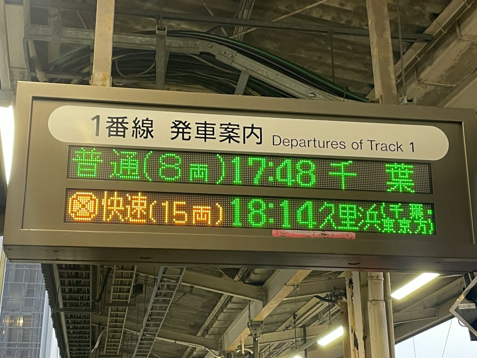 Panel de información de salidas en la vía 1 que muestra los horarios de los trenes hacia Chiba y Kurihama