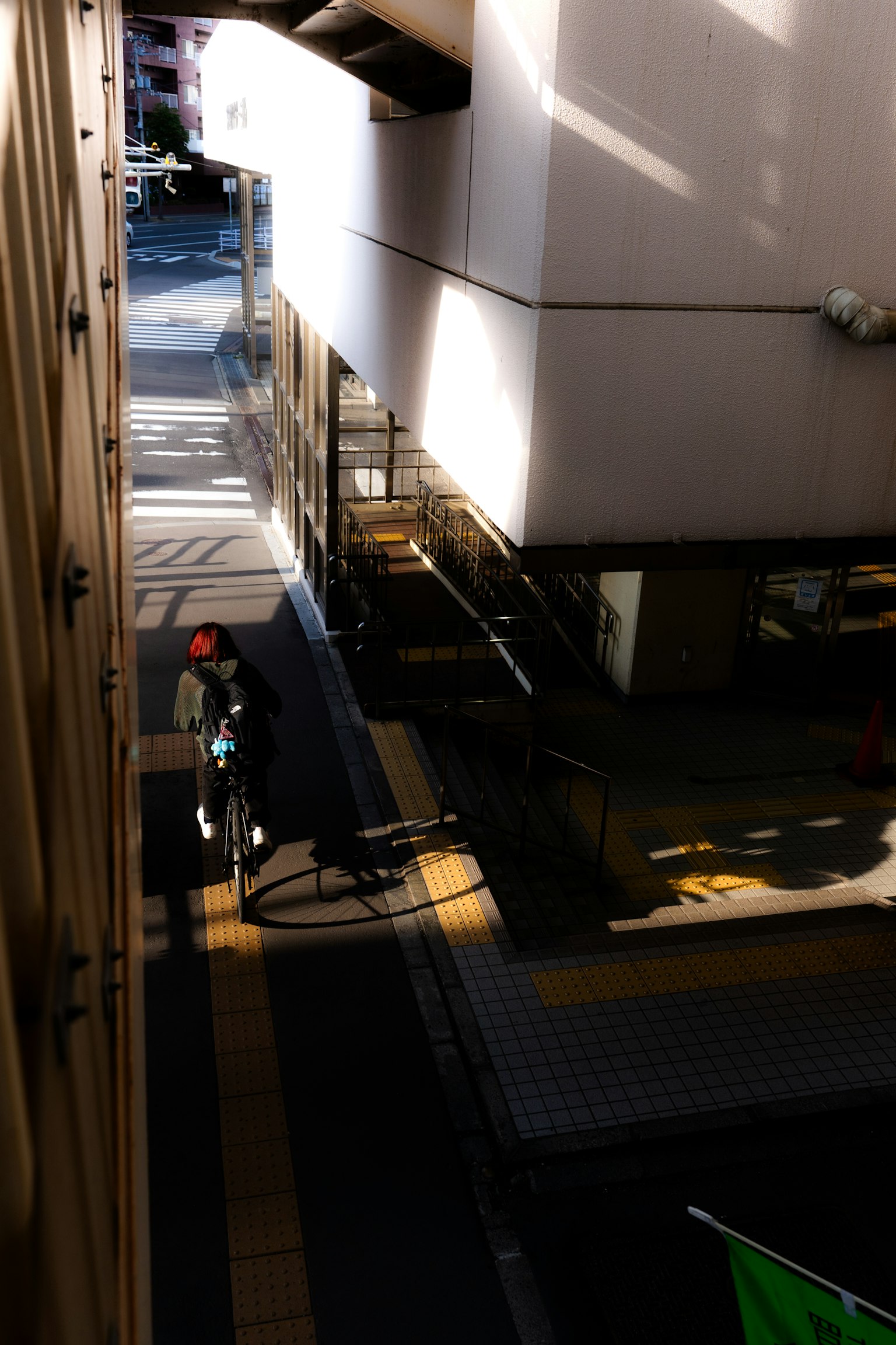 Worker standing in a narrow alley with shadows of buildings