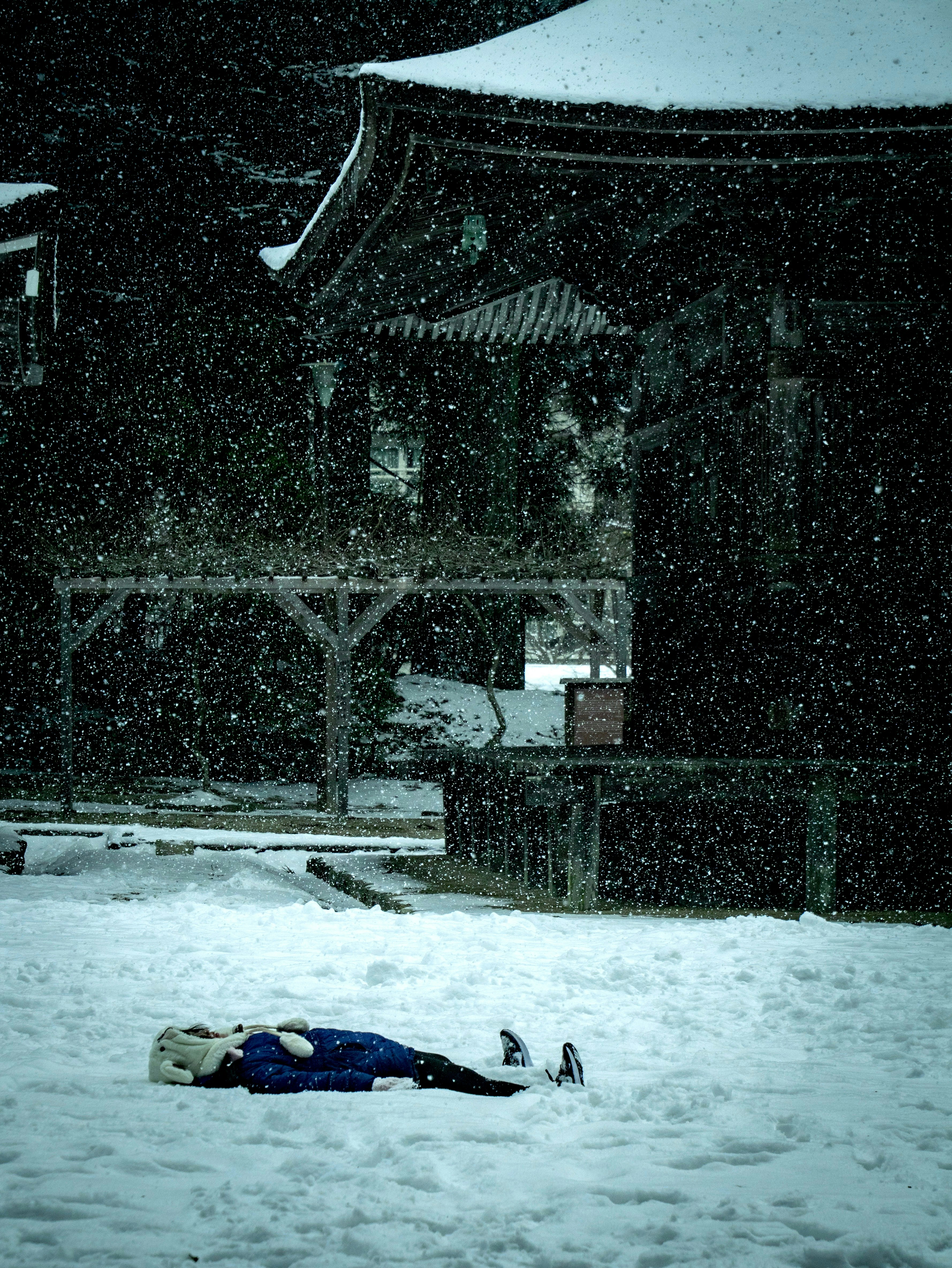 雪の中で横たわる人と背景の伝統的な建物