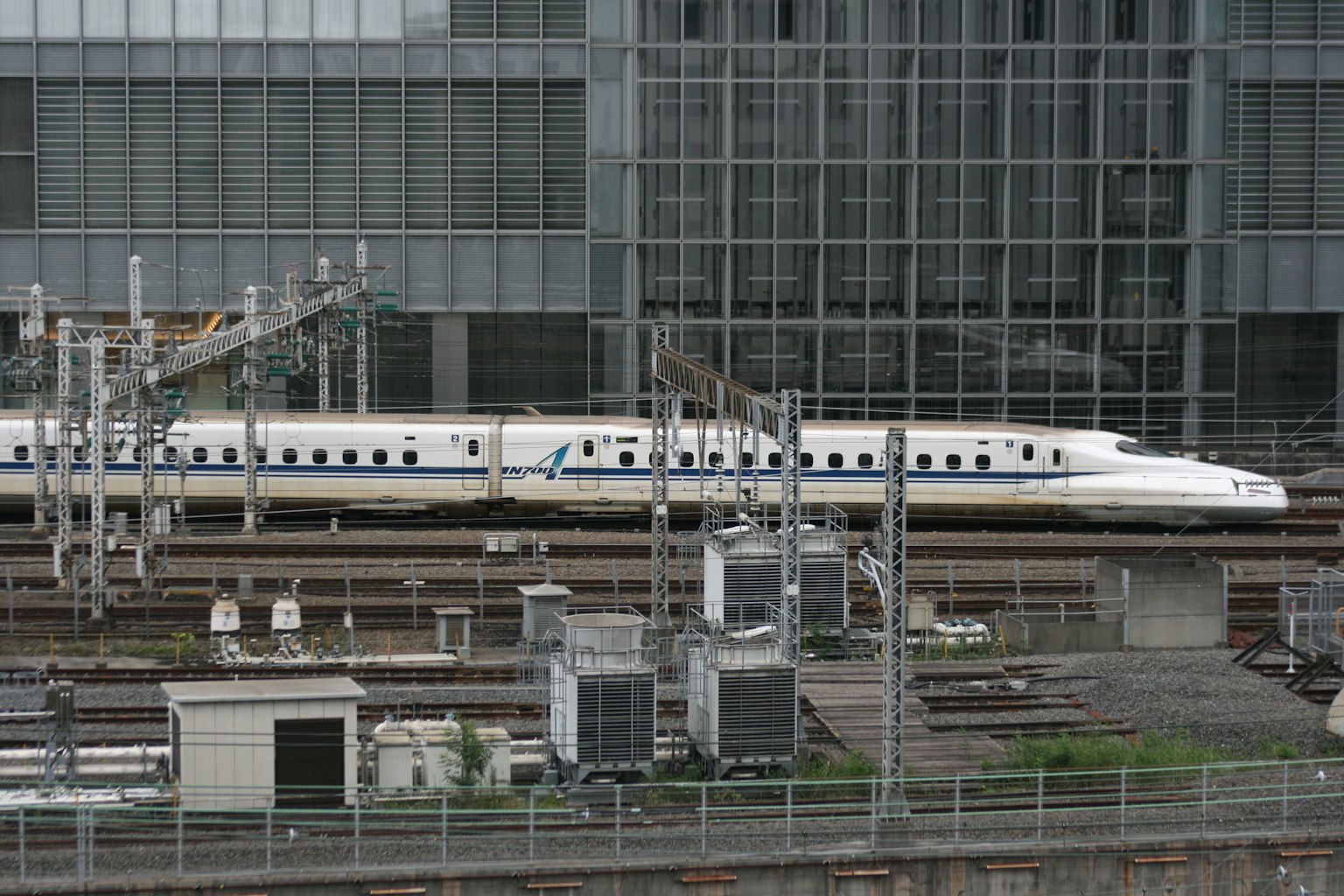 Treno Shinkansen fermo in una stazione con edifici moderni sullo sfondo