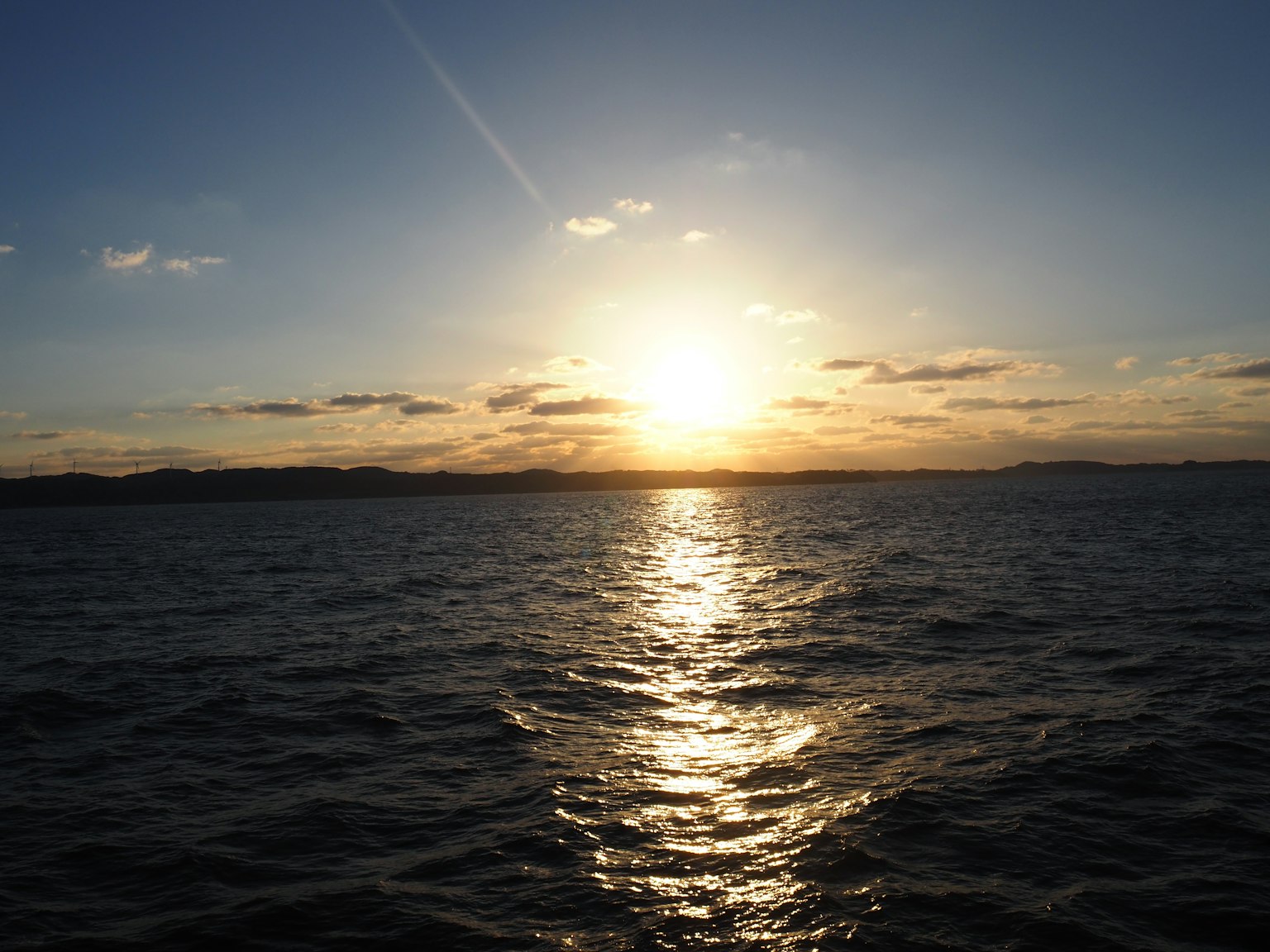海上日落與雲彩及閃爍的水面