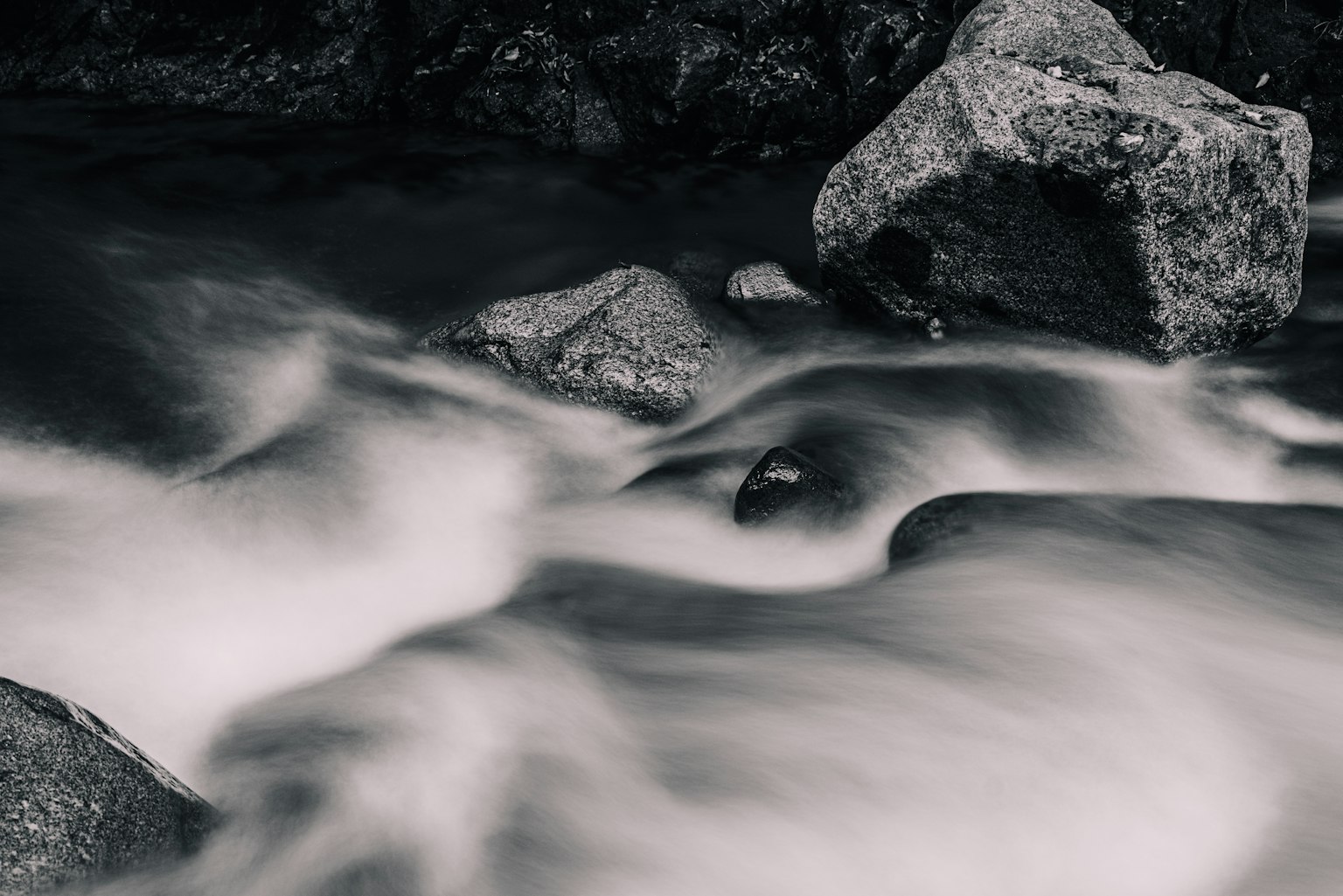 Imagen en blanco y negro de agua fluyendo y rocas