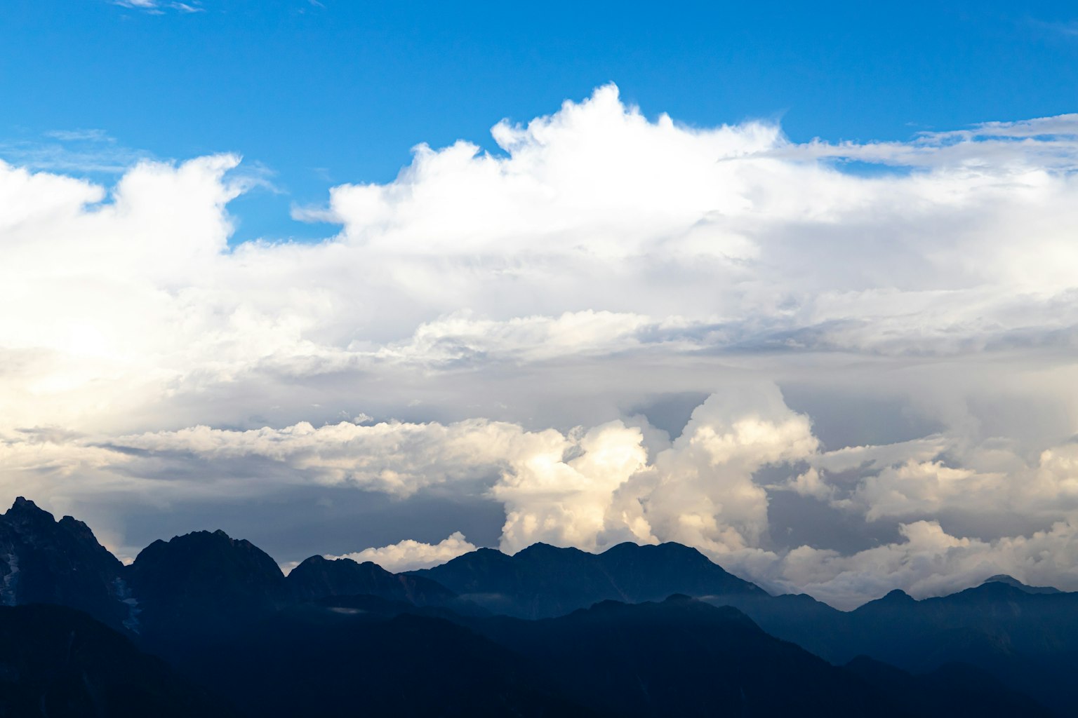 Berglandschaft mit blauem Himmel und weißen Wolken