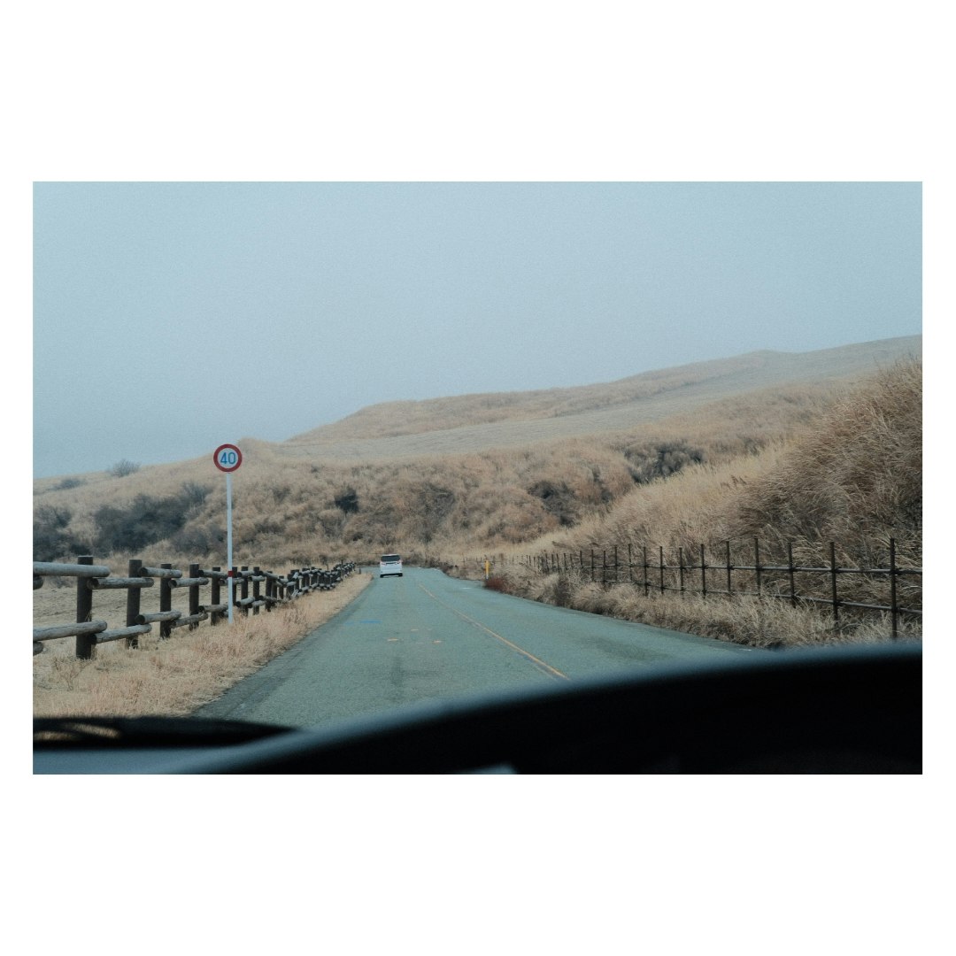 阿蘇の草原を走る一本道の風景