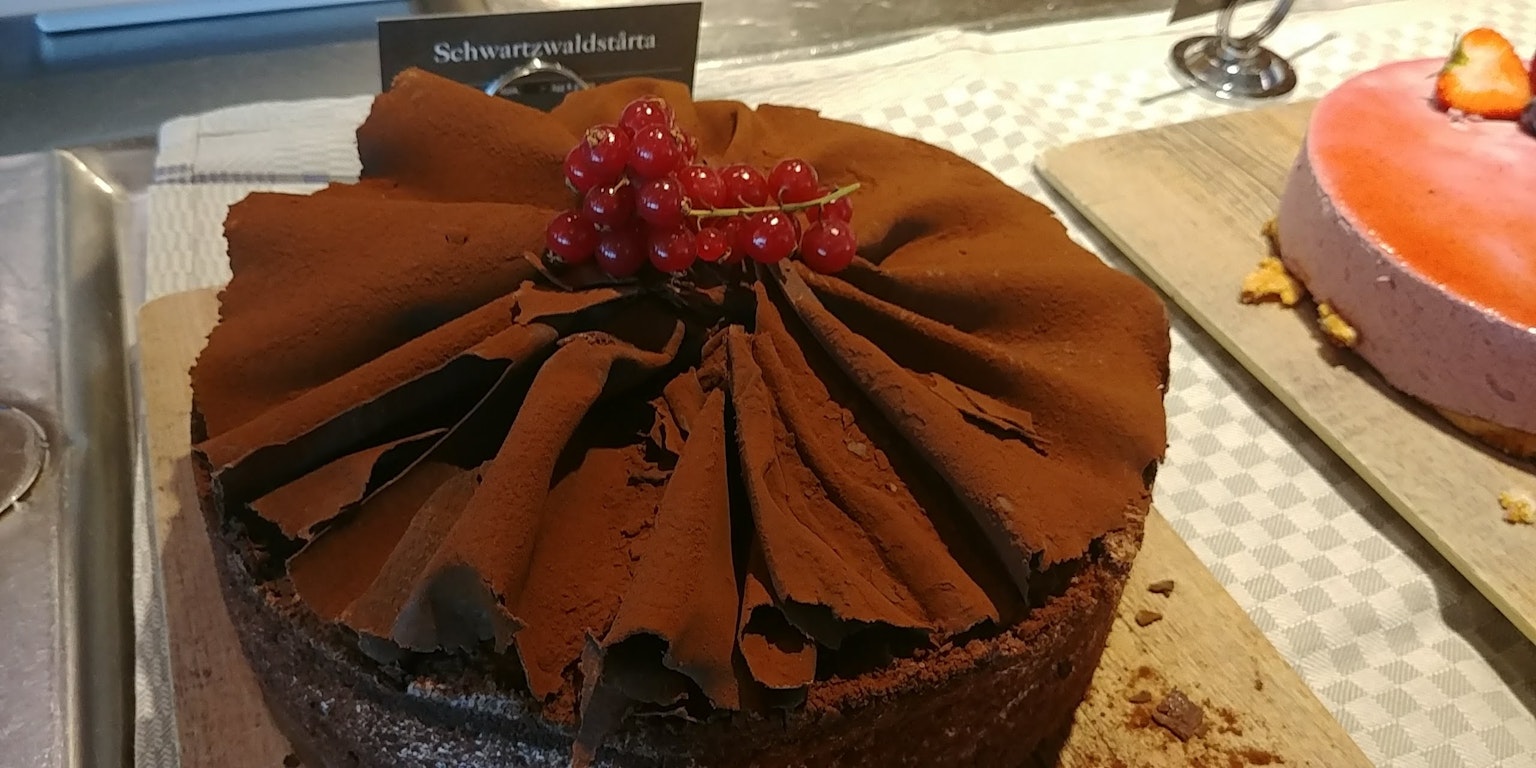 Schokoladenkuchen mit roten Beeren und texturiertem Schokoladenglasur