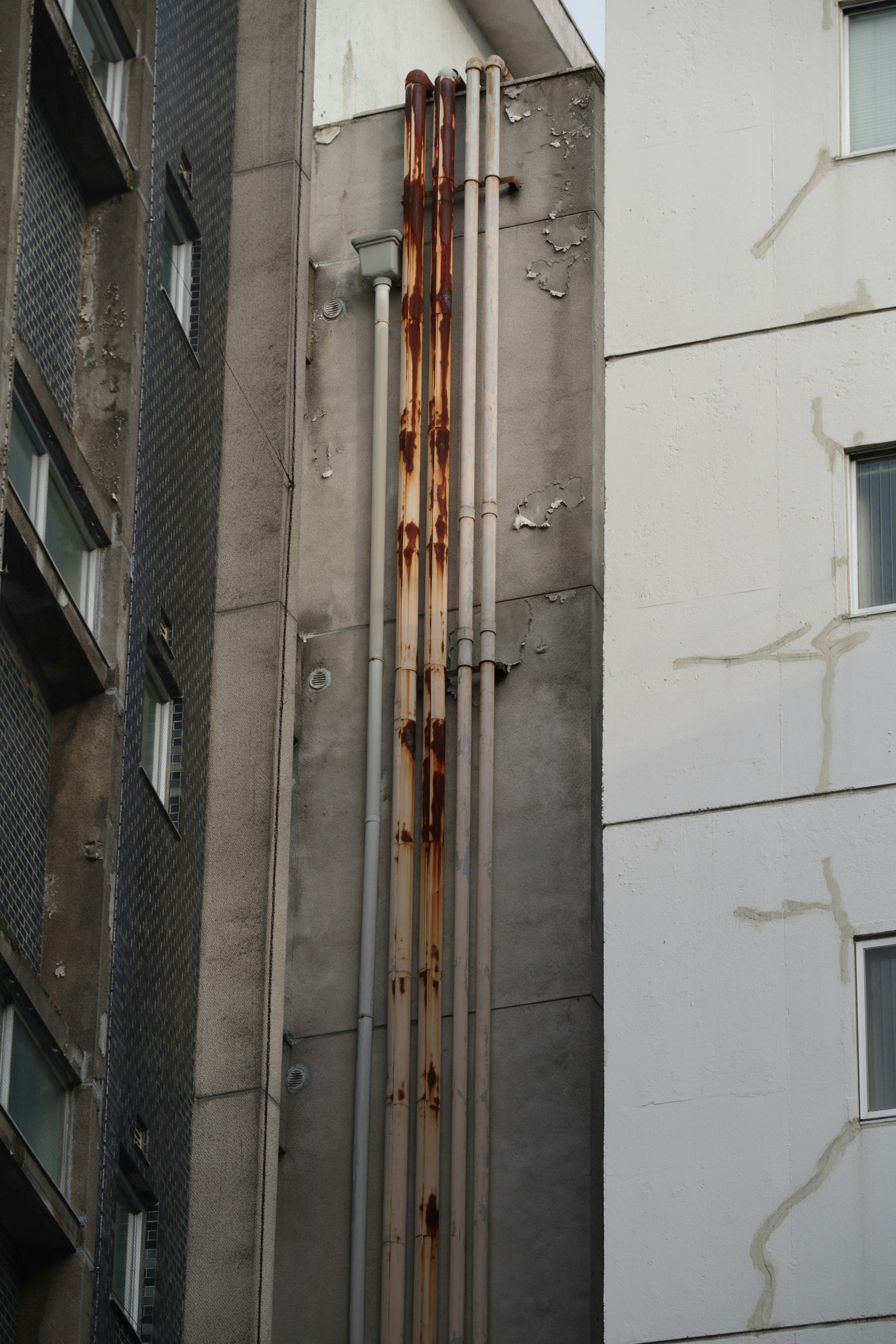 Rusty pipes along the side of an old building