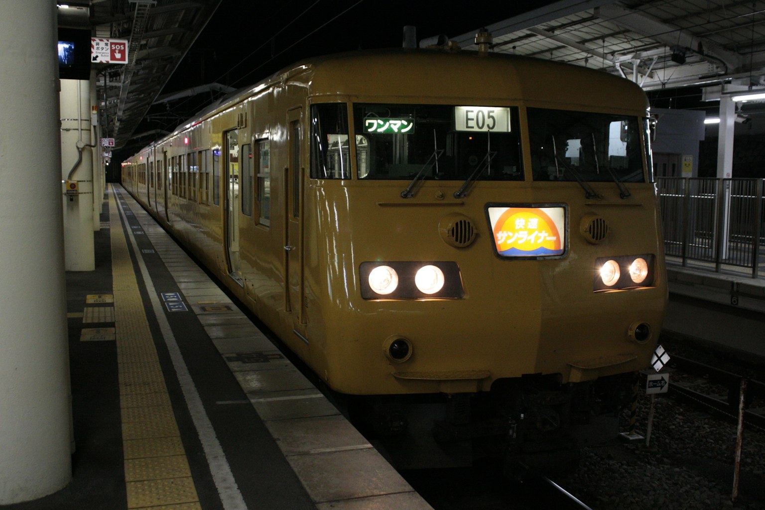Train jaune arrêté à la station de nuit lumières brillantes illuminées à l'avant