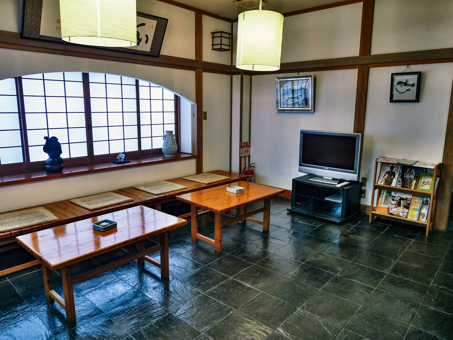 Traditionelles japanisches Interieur mit Holztischen und Bodenkissen Natürliches Licht strömt durch das Fenster