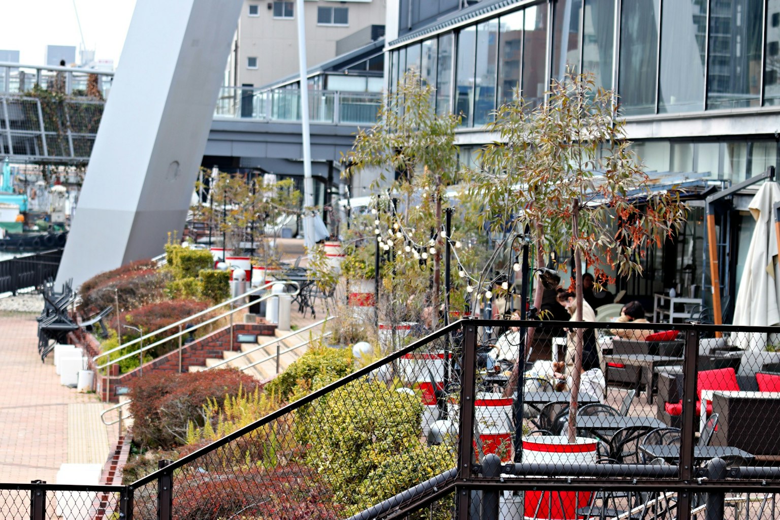 Moderne Restaurantterrasse mit üppigem Grün und Außenbestuhlung