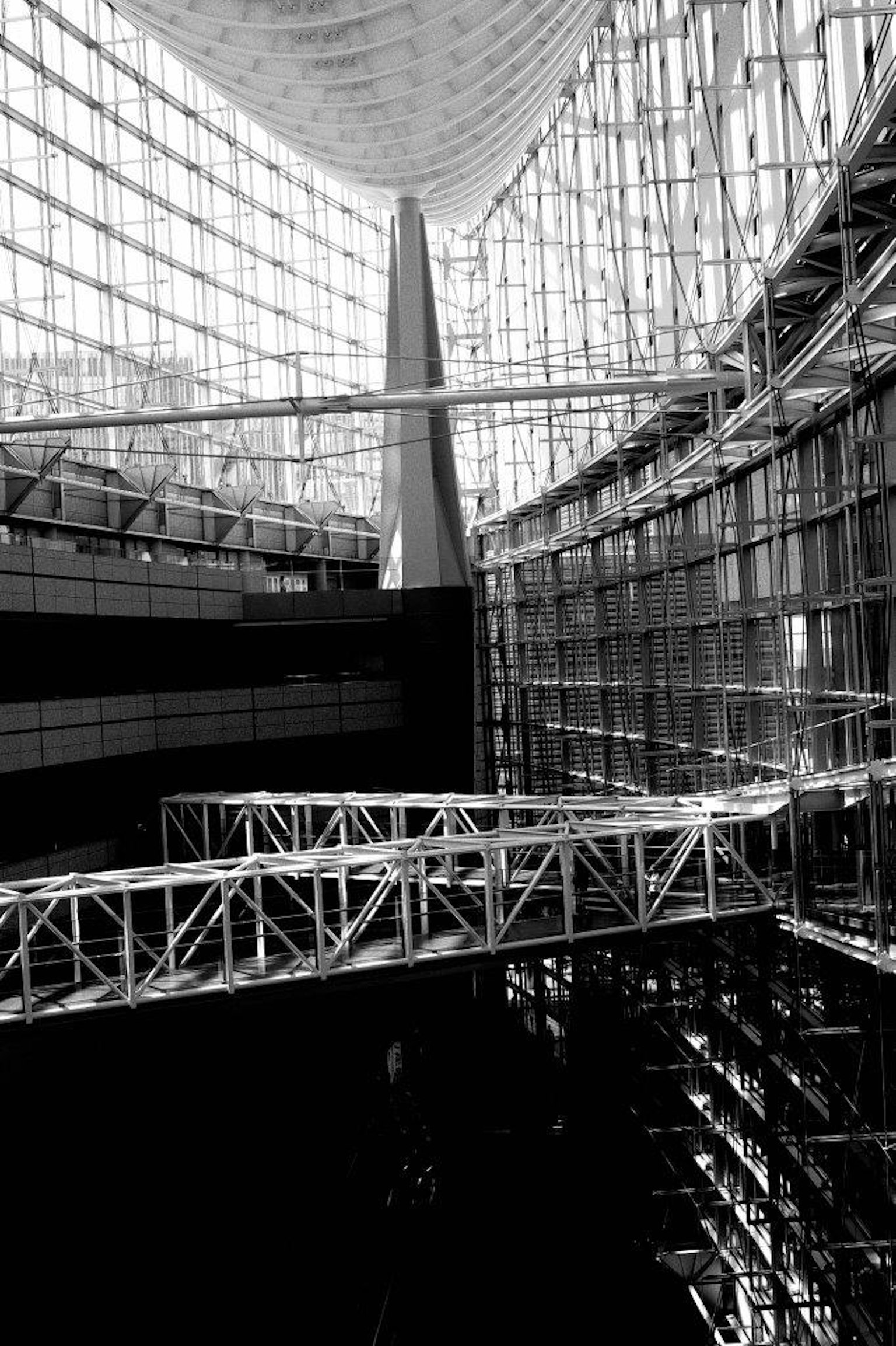 Vista interna di un'architettura moderna che mostra grandi pareti in vetro e una struttura metallica