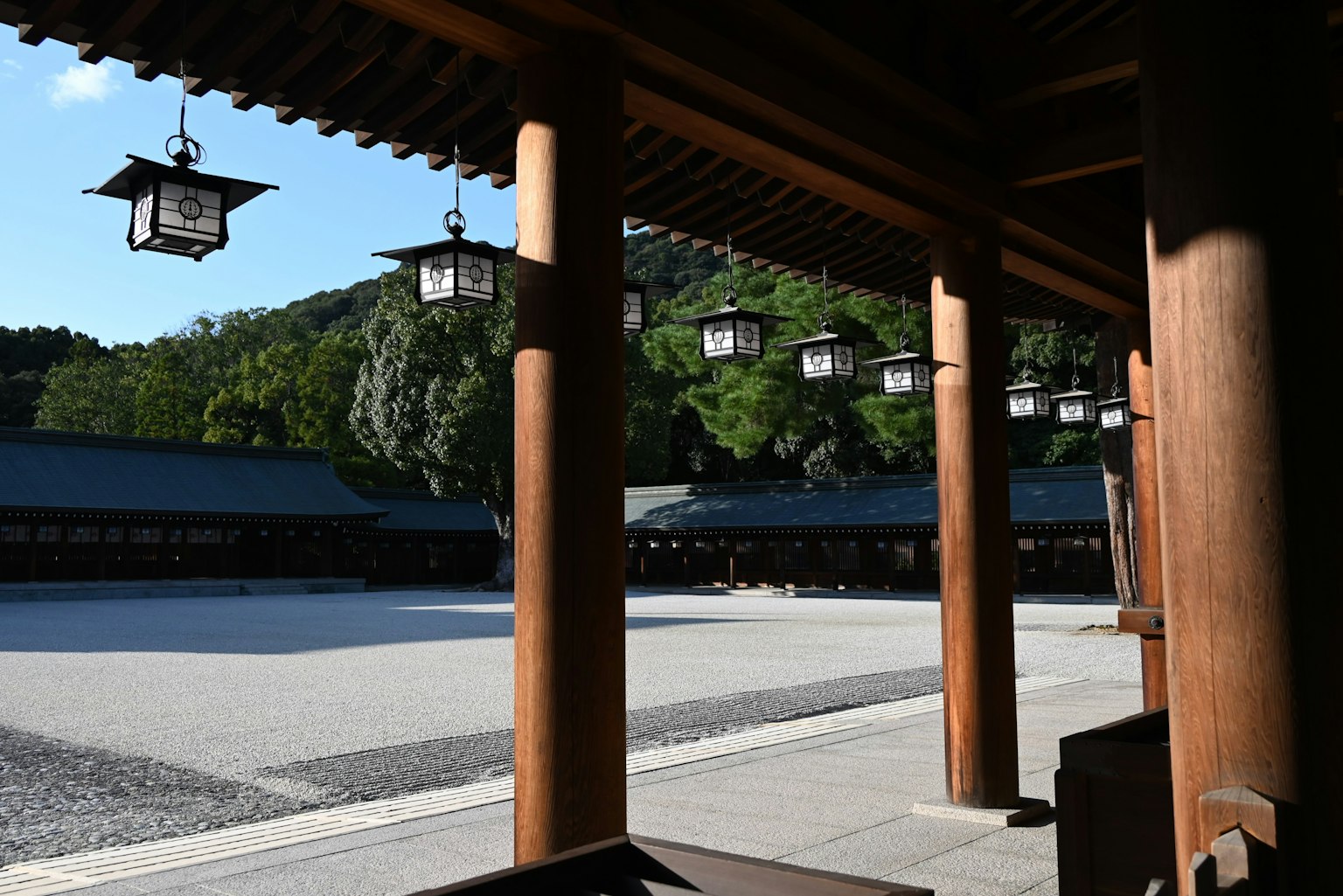 ทิวทัศน์ของลานศาลเจ้าที่เงียบสงบพร้อมเสาไม้และโคมไฟ