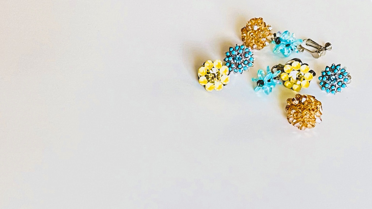 Accessoires de fleurs en perles colorées éparpillés sur un fond blanc
