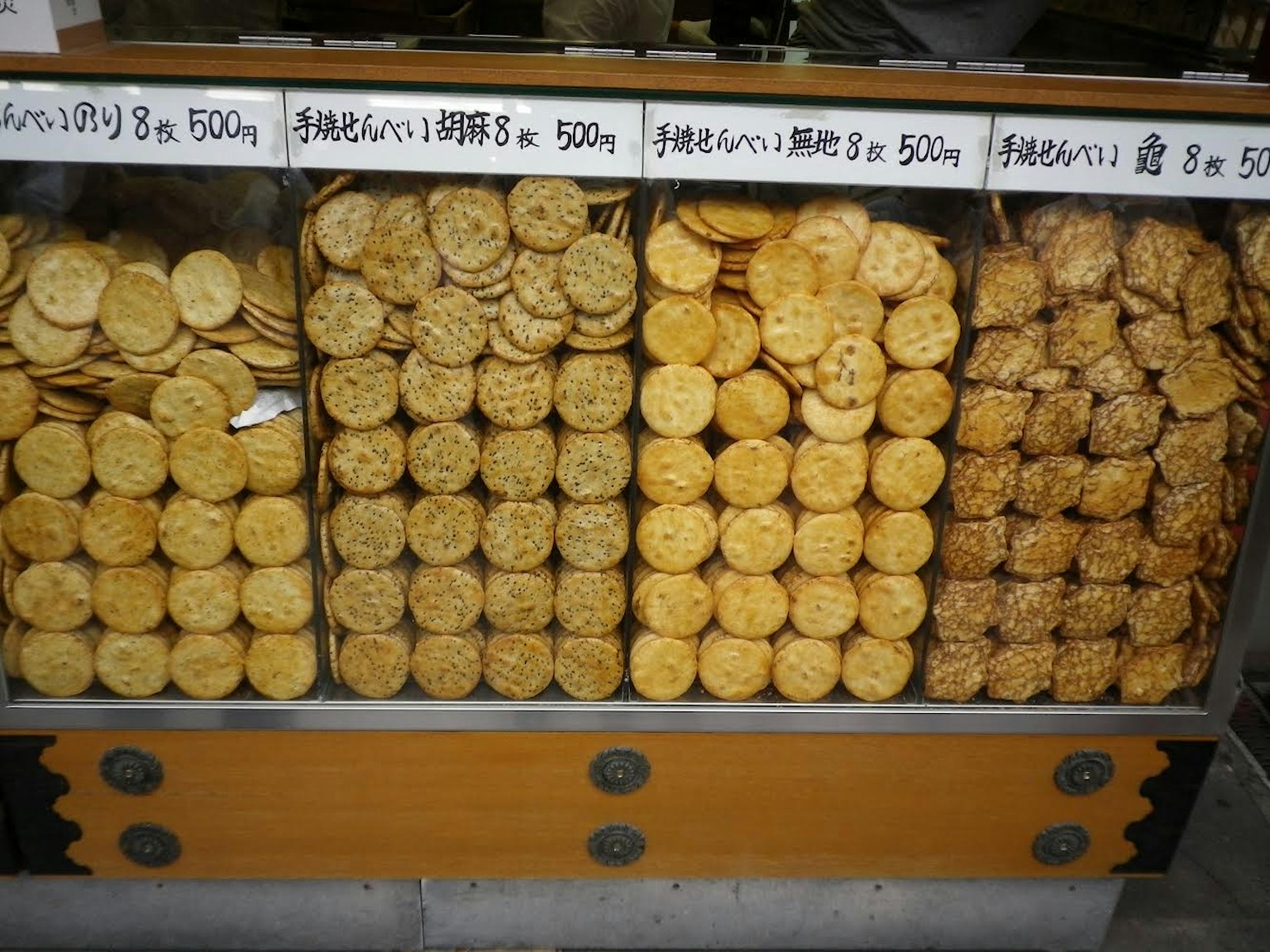 Una esposizione di vari tipi di cracker di riso e snack disposti su uno scaffale di negozio